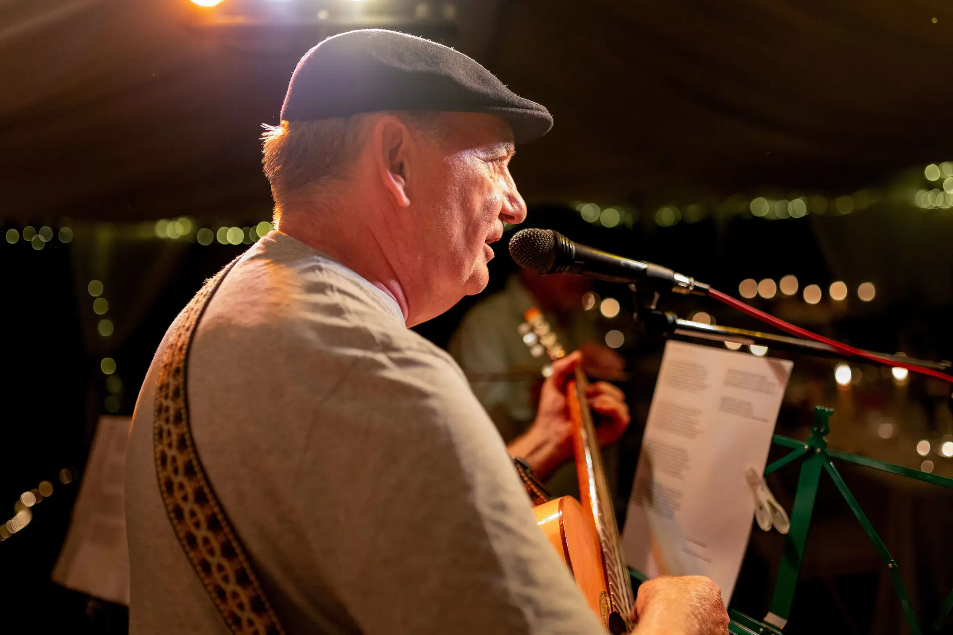 Musiker spielt Gitarre und singt am Mikrofon bei der Hochzeitsparty