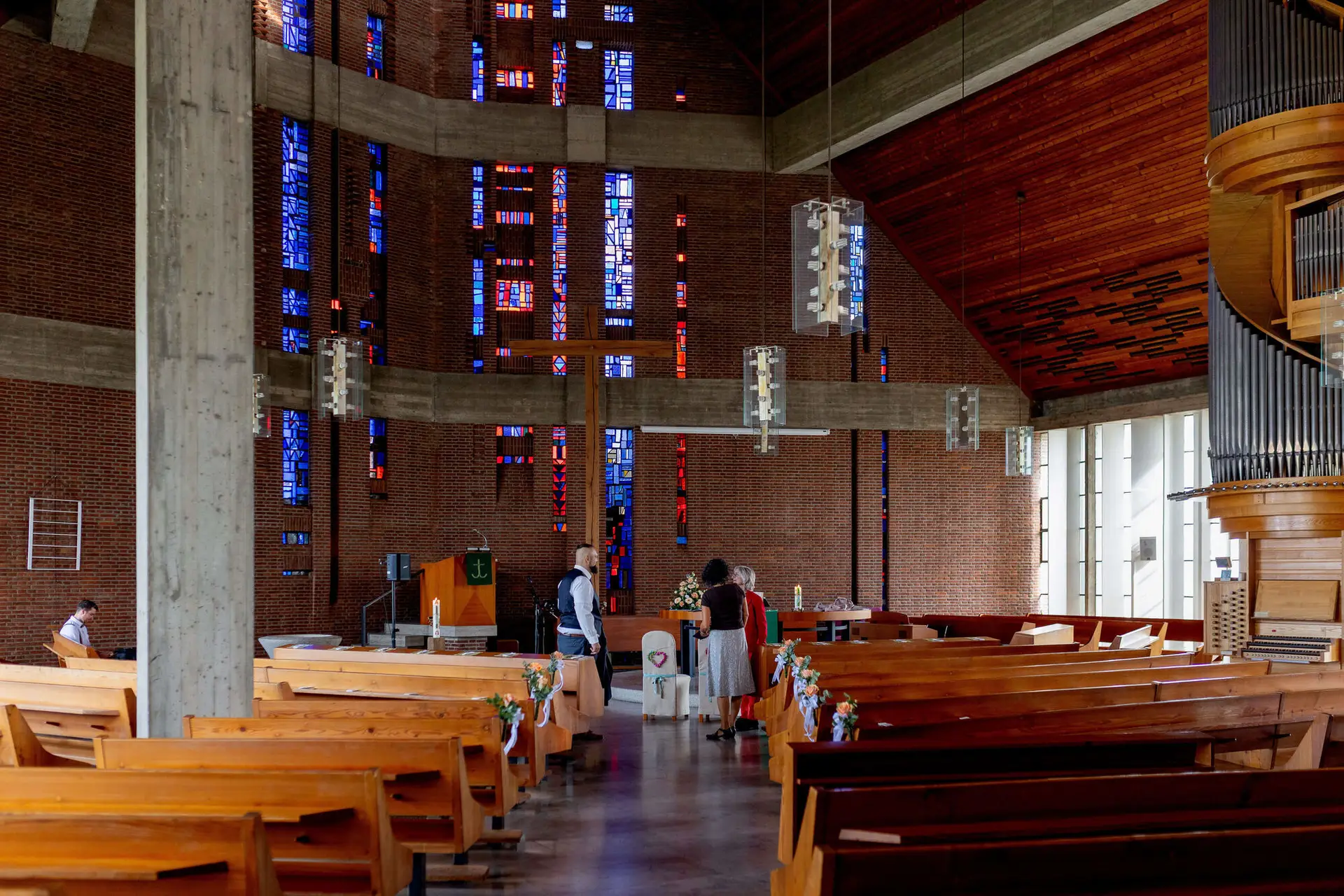 Innenraum der Christuskirche Speyer mit bunten Glasfenstern und Holzbänken