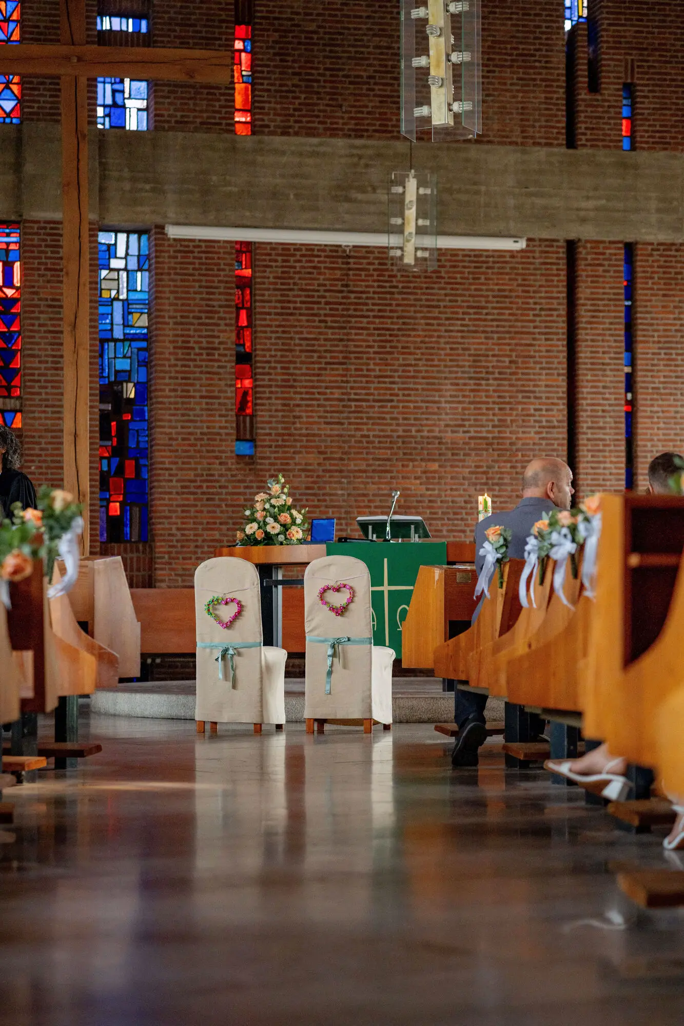 Blick durch den Mittelgang auf die geschmückten Stühle und den Altar