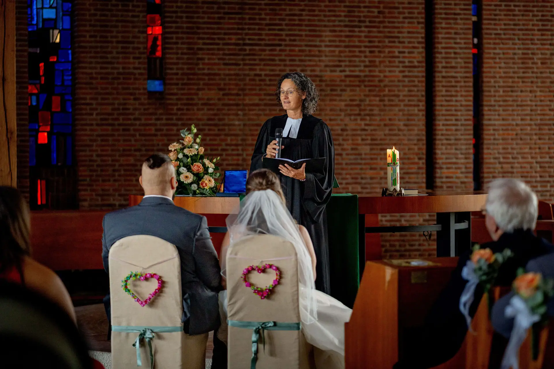 Pfarrerin spricht vor dem sitzenden Brautpaar in der Christuskirche