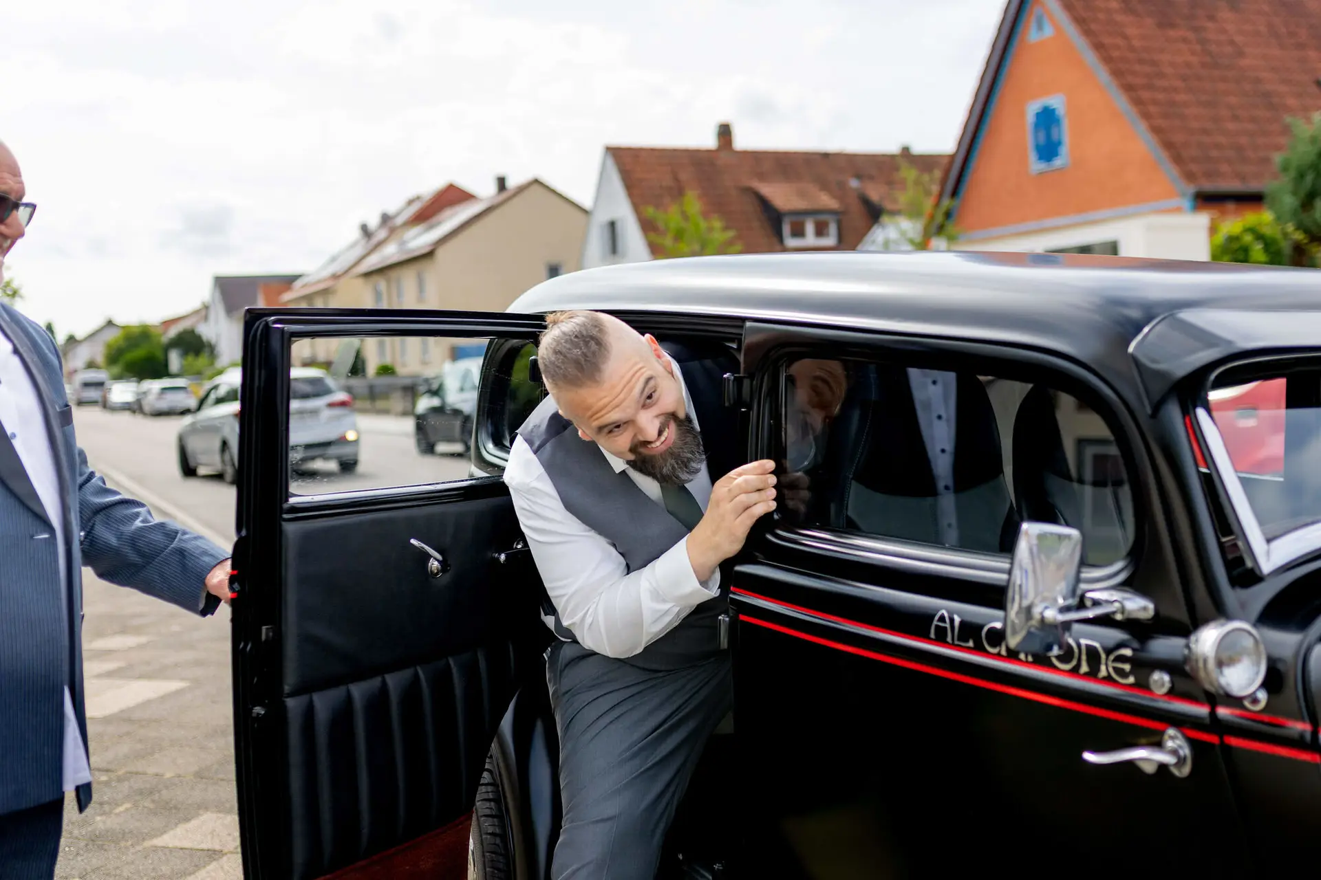 Bräutigam steigt in schwarzen Oldtimer mit Al-Capone-Schriftzug
