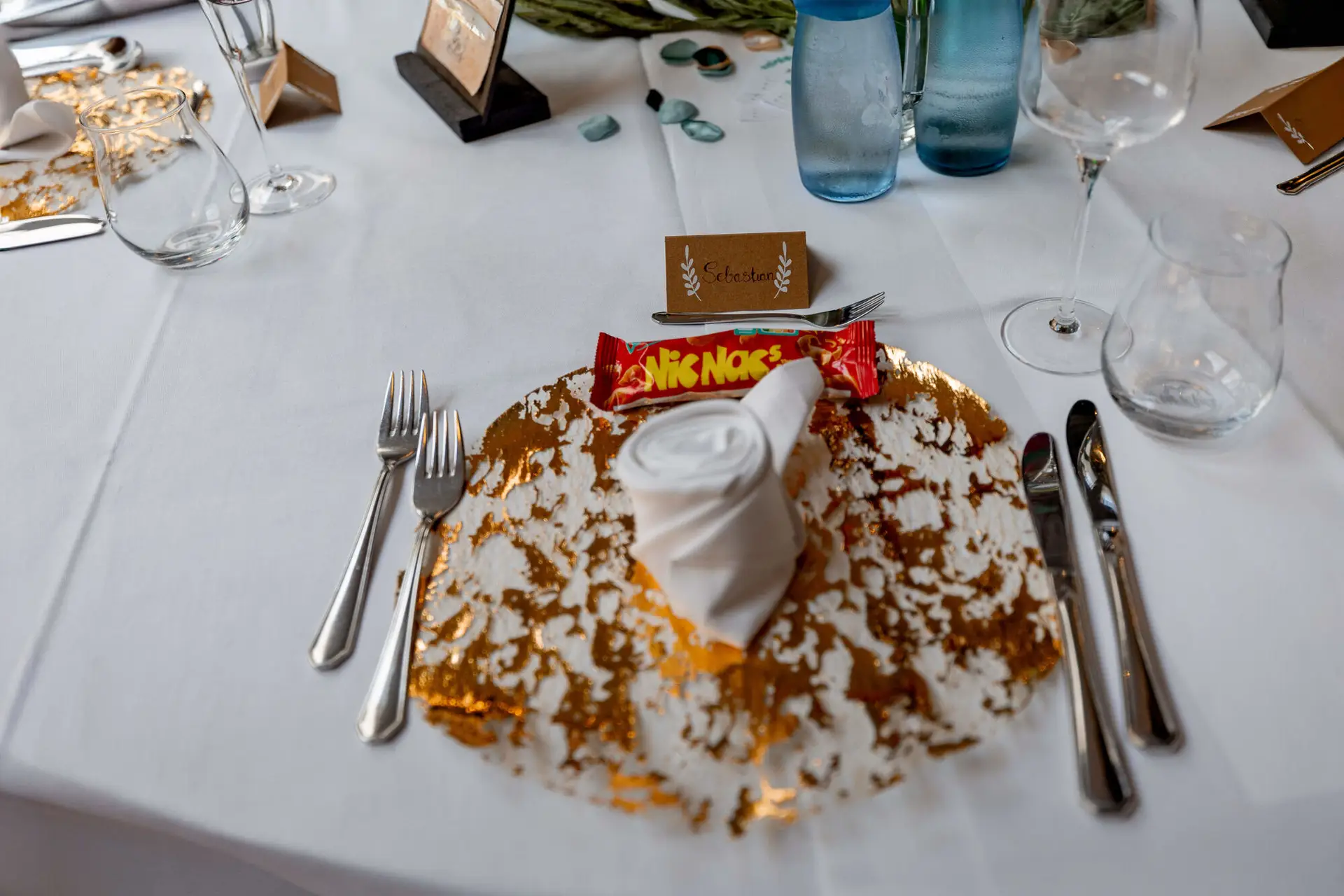 Gedeck mit goldenem Platzteller und Namenskarte