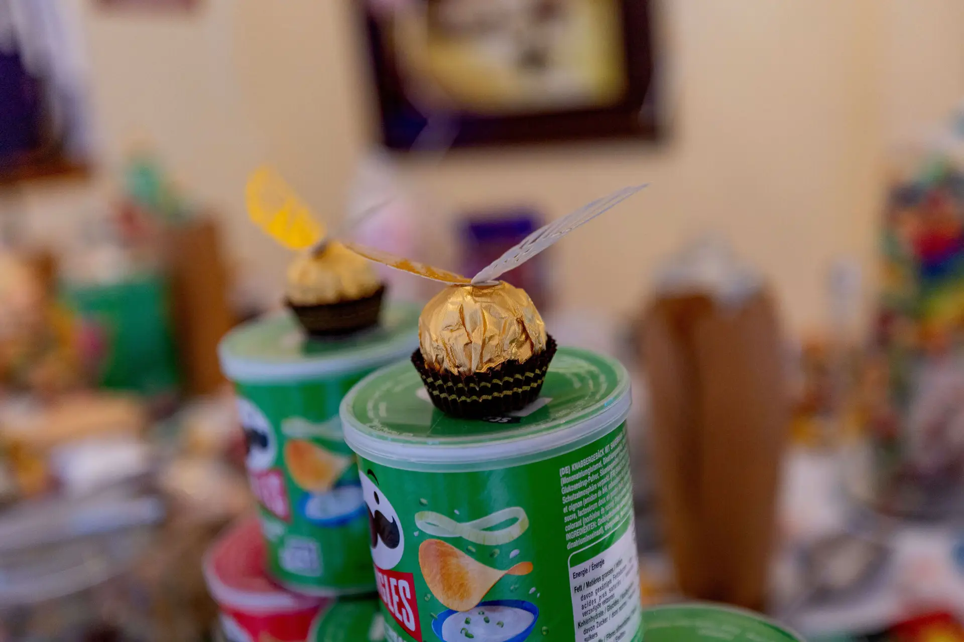Goldener Schnatz aus Ferrero Rocher auf Pringles-Dose in Nahaufnahme