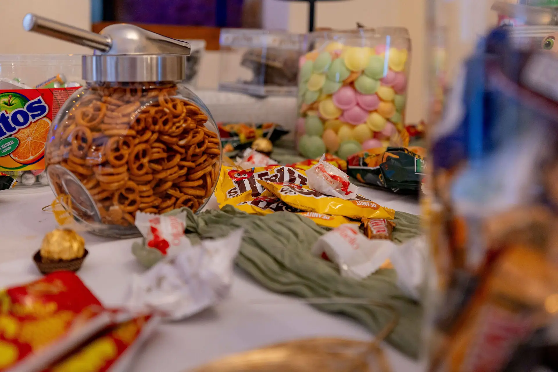 Brezelglas und bunte Süßigkeiten auf der Candy-Bar