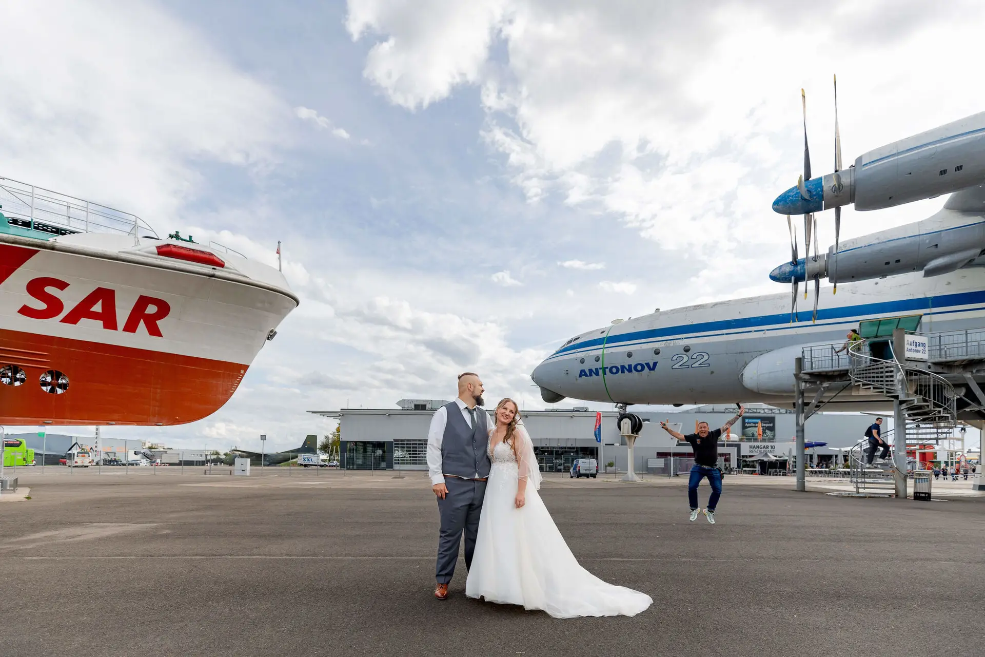 Brautpaar steht zwischen SAR-Schiff und Antonov 22 auf dem Museumsgelände