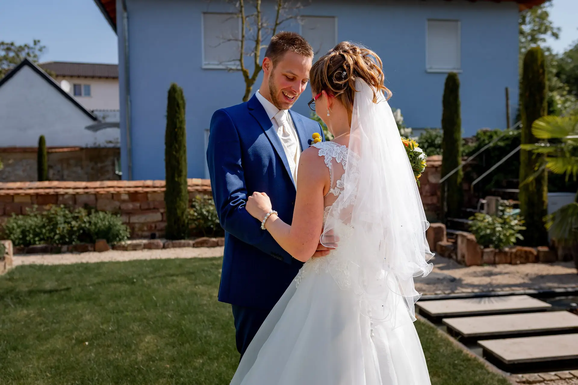 Braut und Bräutigam lächeln sich liebevoll an, umgeben von sattem Grün in der pfälzischen Landschaft