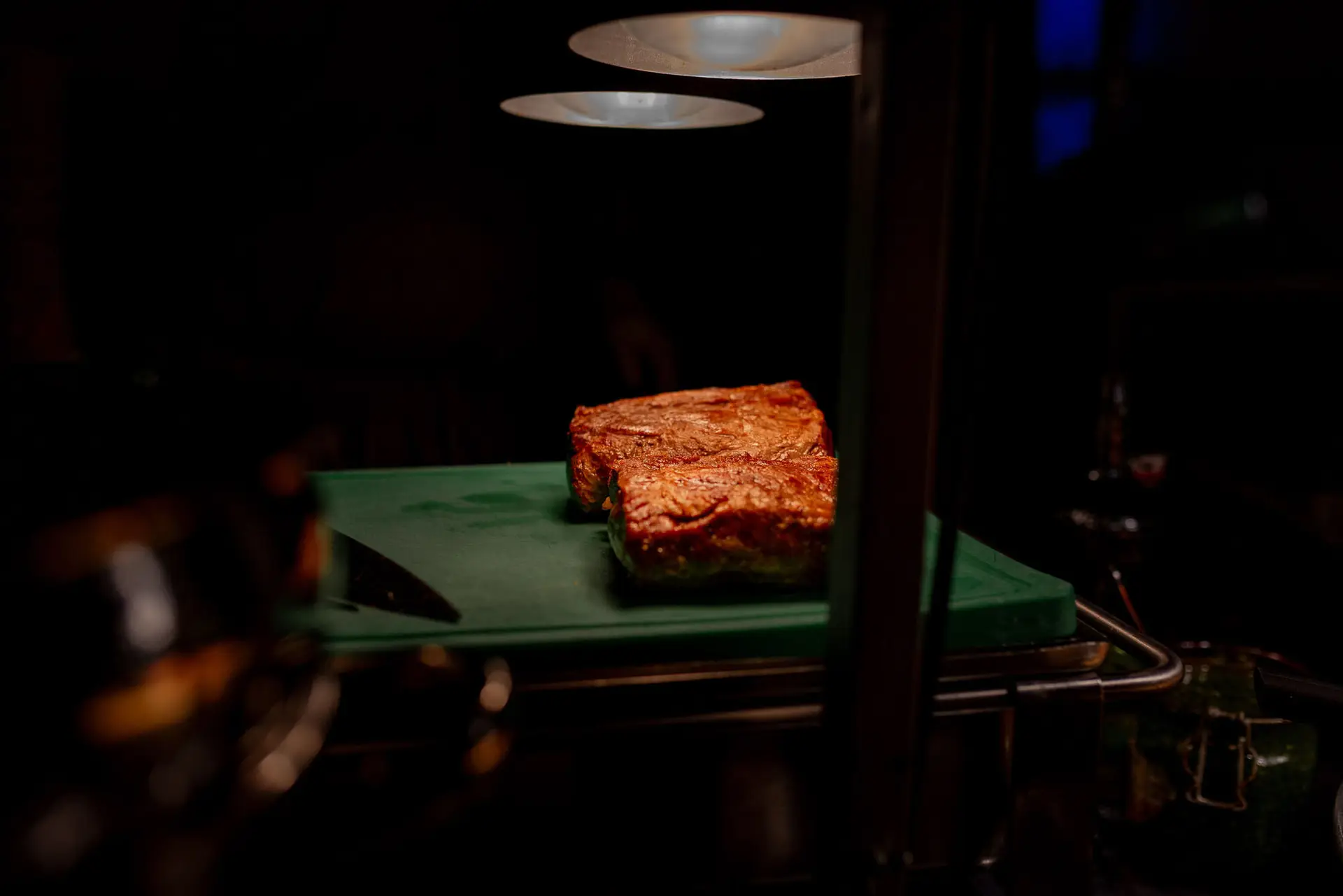 Zartes Rindfleisch auf grüner Unterlage, perfekt angerichtet unter Scheinwerferlicht beim Hochzeitsmenü