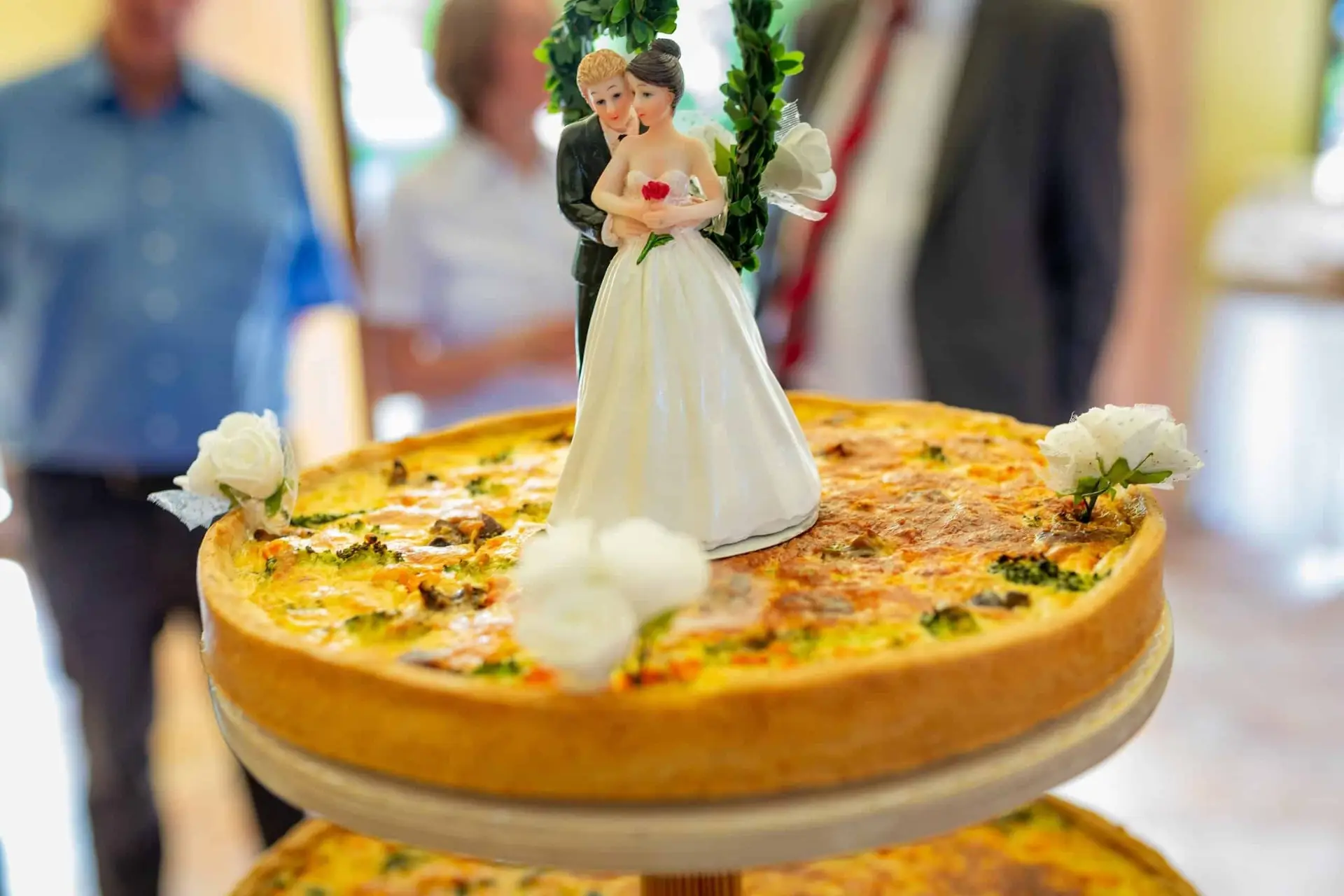 Hochzeitsfigur auf einem Geldbrot mit weißen Blüten – Kuchendeko-Detail bei der Hochzeitsfeier