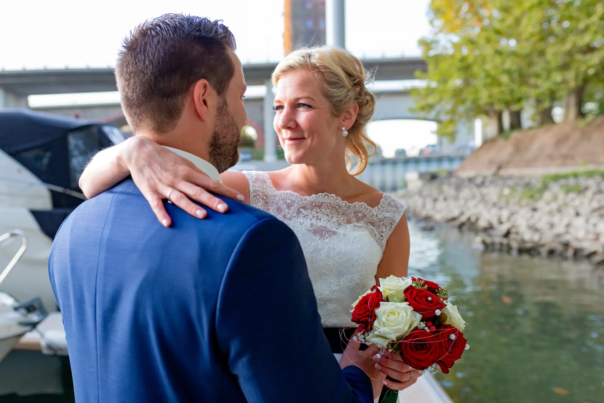 Brautpaar umarmt sich am Yachthafen Worms mit Brückenturm im Hintergrund