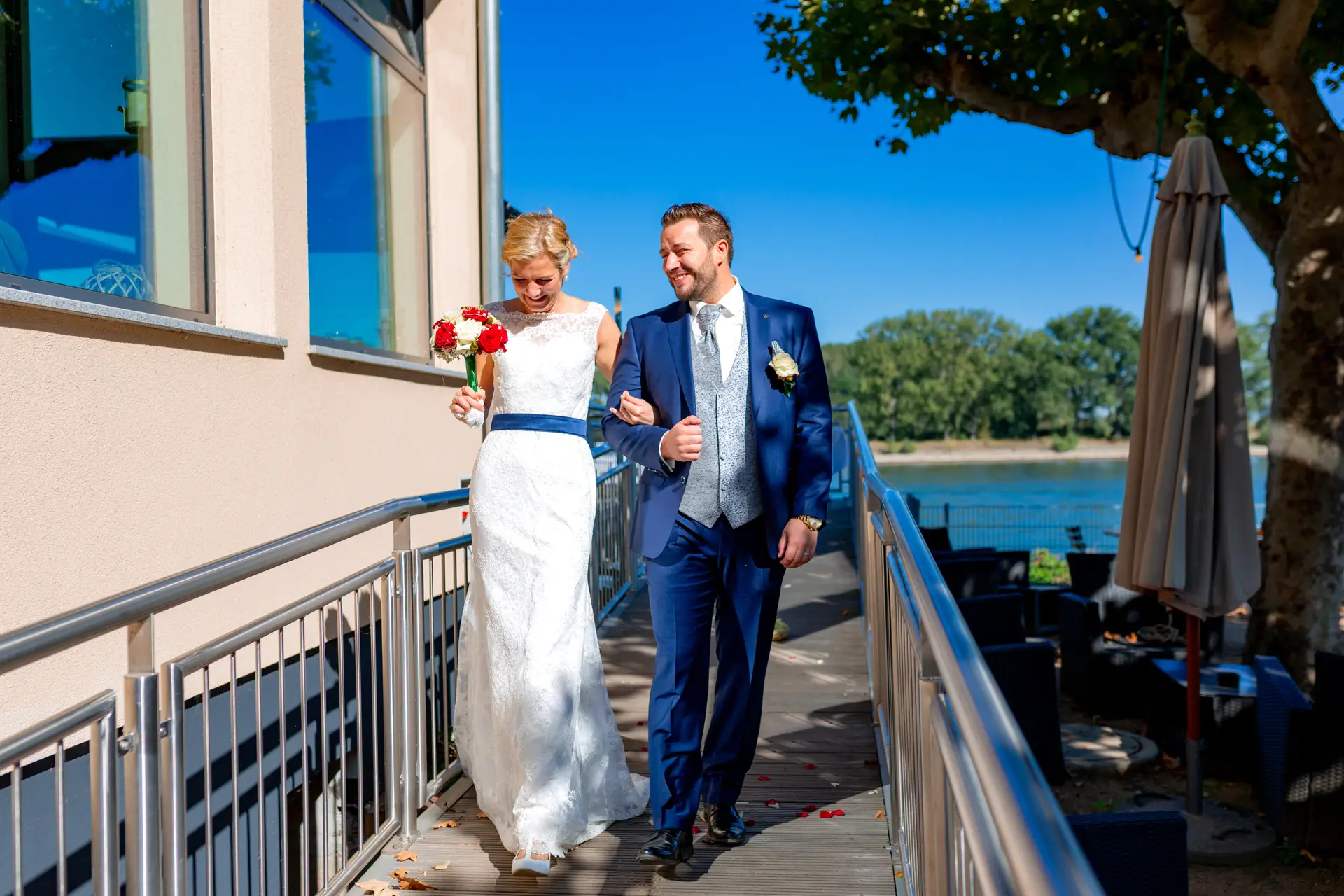 Brautpaar läuft am Geländer entlang direkt am Rhein nach der Trauung im Alten Ruderhaus Worms