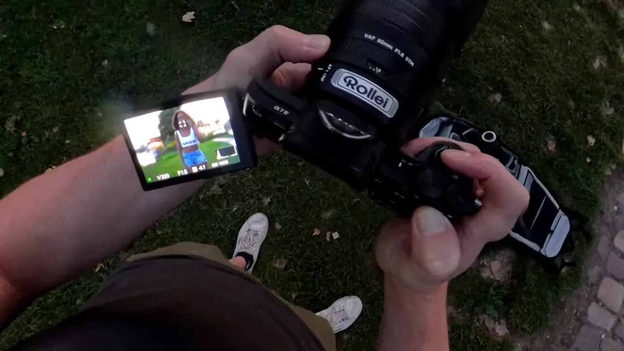 Blick auf Kameradisplay im Live‑View: Fotograf hält Kamera mit aufgeklapptem Monitor, auf dem ein Modell im Fokus zu sehen ist.