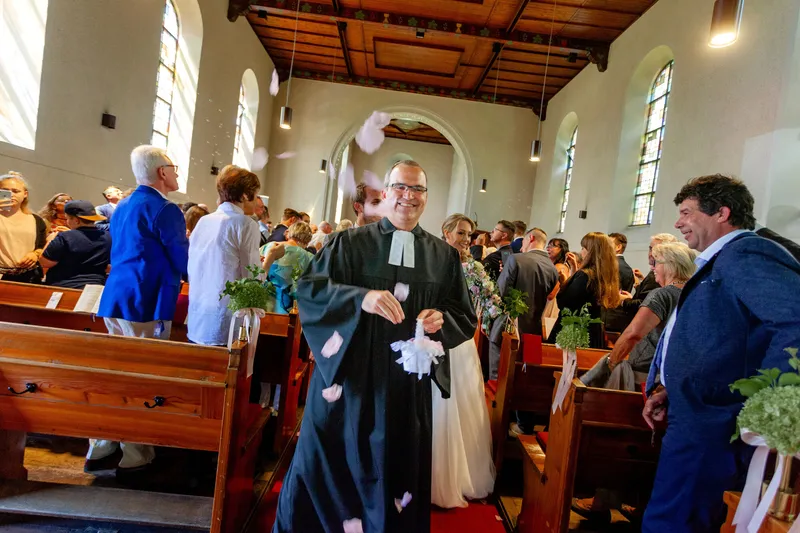 Blumen Werfender Priester Auf Einer Hochzeit In Mannheim.DFXKoS46 Hochzeitsfotograf Mannheim: Priester wirft Blumen bei kirchlicher Trauung