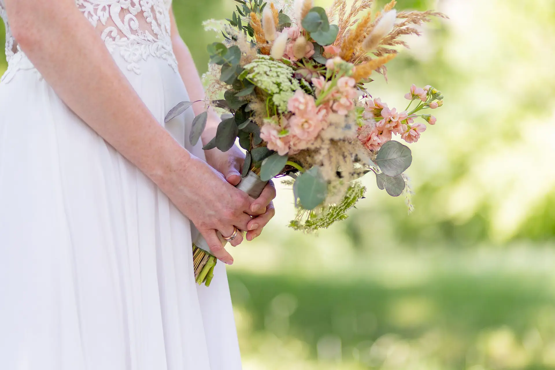 Nahaufnahme der Braut mit Blumenstrauß aus Pastelltönen im Schlossgarten Herrnsheim