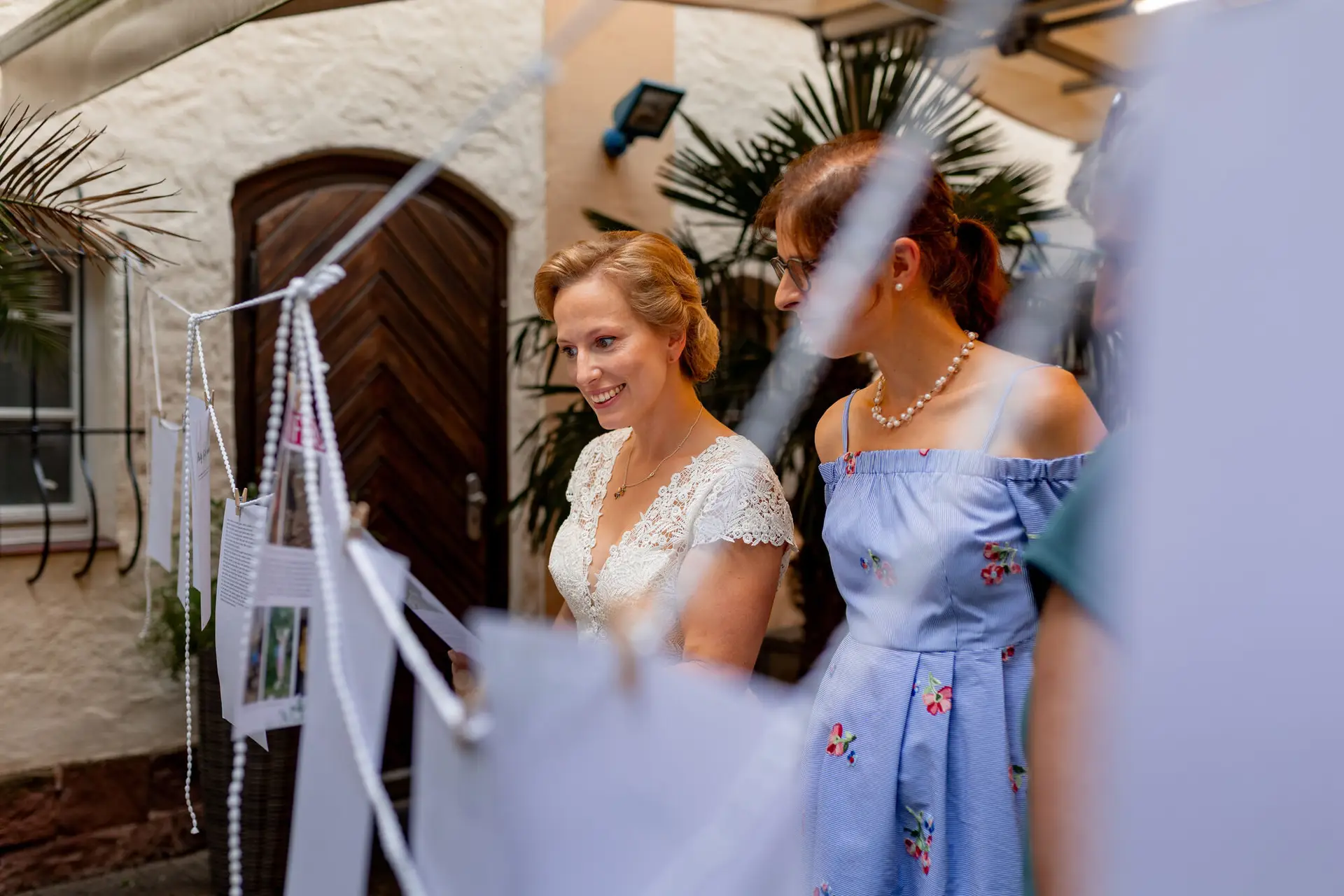 Braut und Brautjungfer lächeln vor dem historischen Backsteinhaus der Majolika Manufaktur Karlsruhe