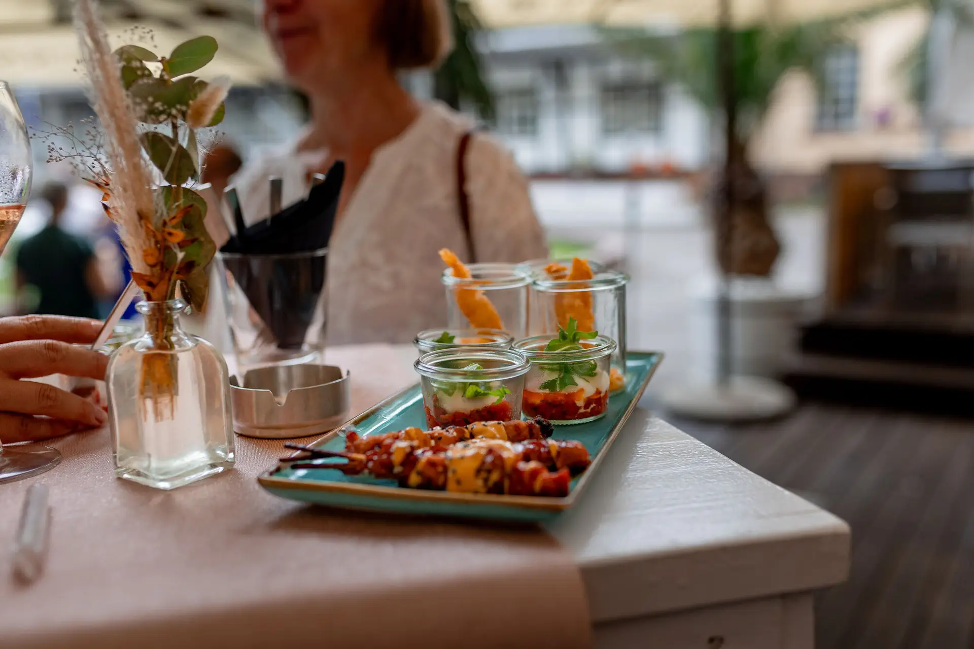 Tablett mit Fingerfood und Wein beim Sektempfang nach der freien Trauung, Blumendekoration im Hintergrund