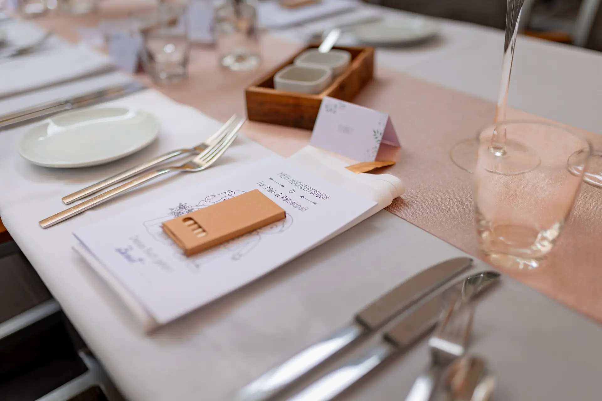 Gedeckter Hochzeitstisch mit Menükarte und Gastgeschenk bei der Feier in der Cantina Majolika