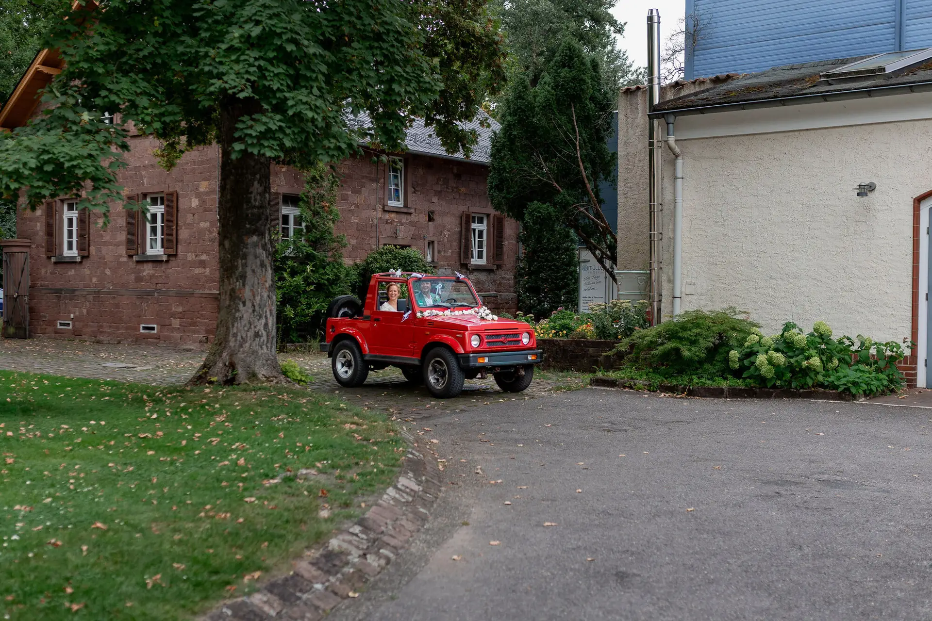 Rotes Geländefahrzeug als Hochzeitsauto mit Rosendeko vor der Majolika Manufaktur Karlsruhe