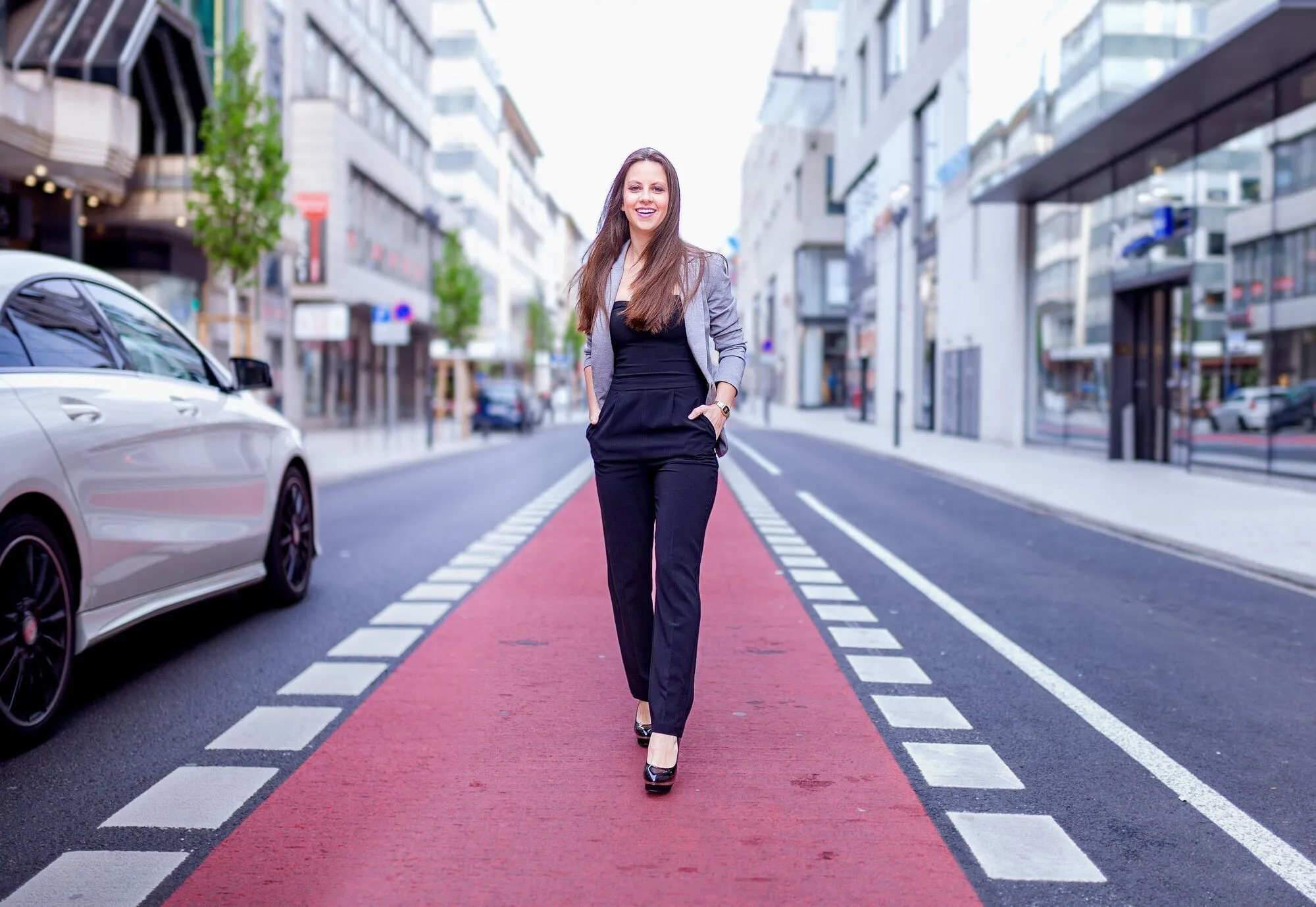 Gina läuft lächelnd über den roten Radweg einer leeren Straße in der Mannheimer Innenstadt