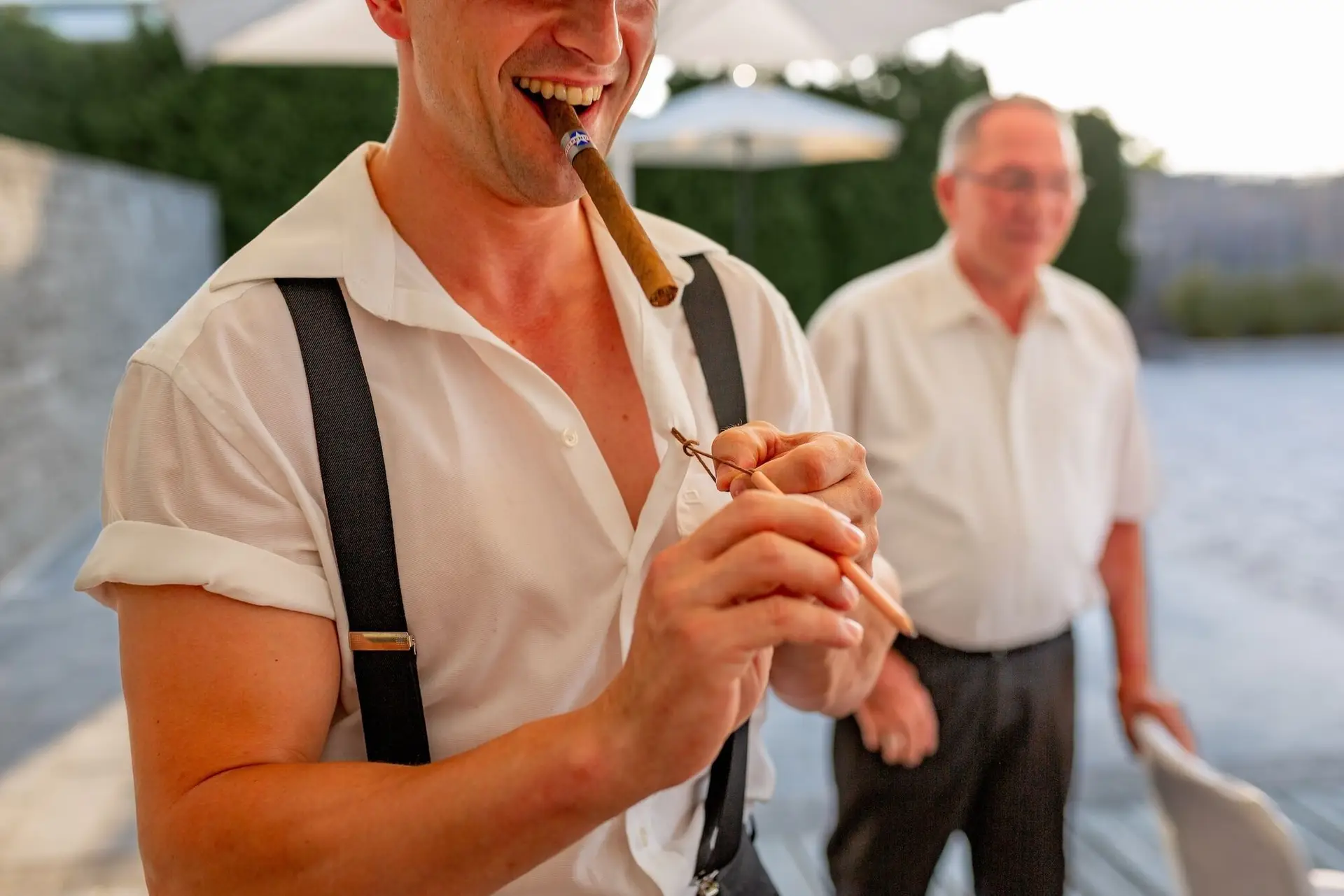 Gast genießt entspannt eine Zigarre bei der Hochzeitsfeier im Freien