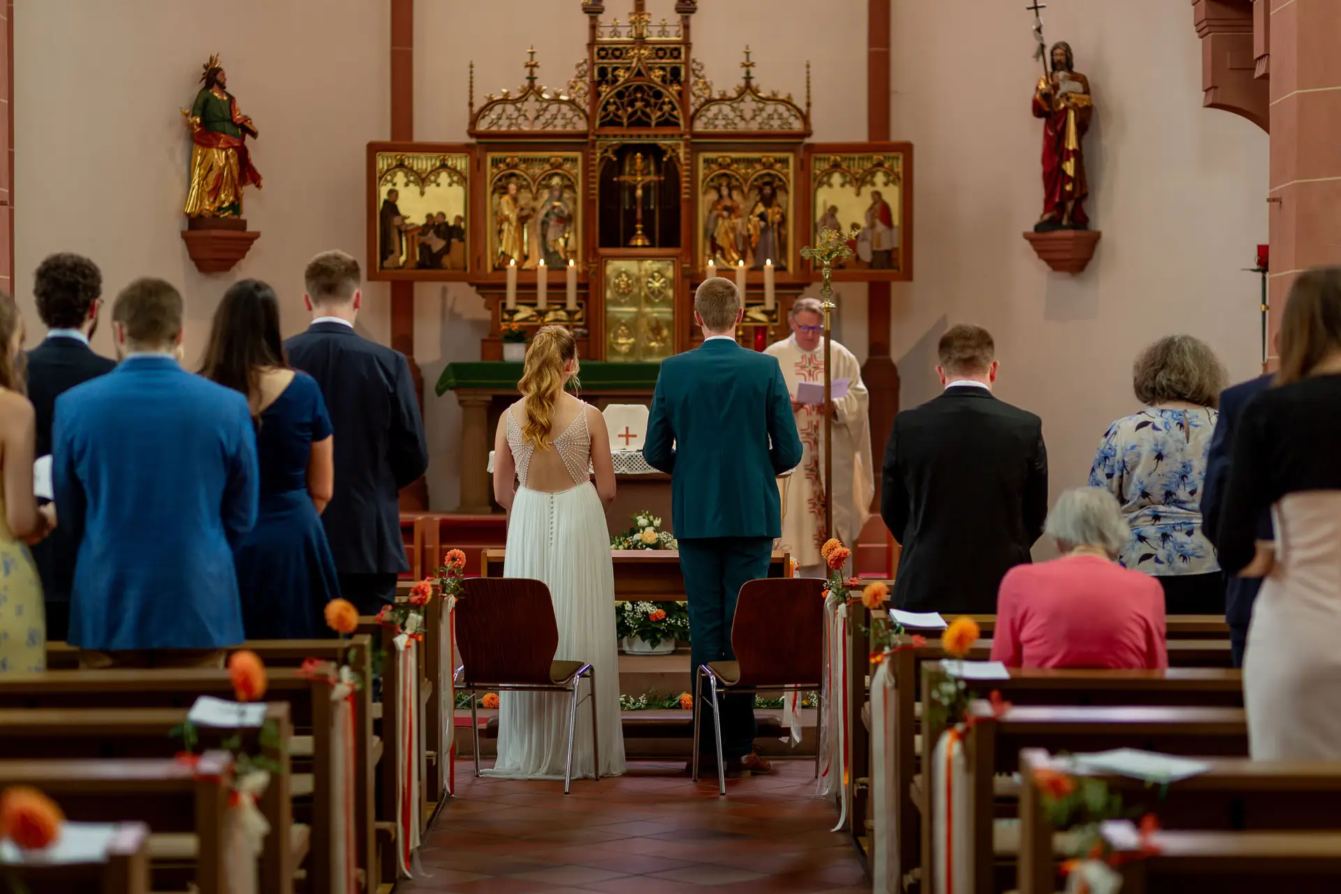 Brautpaar am festlich geschmückten Altar während der kirchlichen Trauung in St. Johannes der Täufer