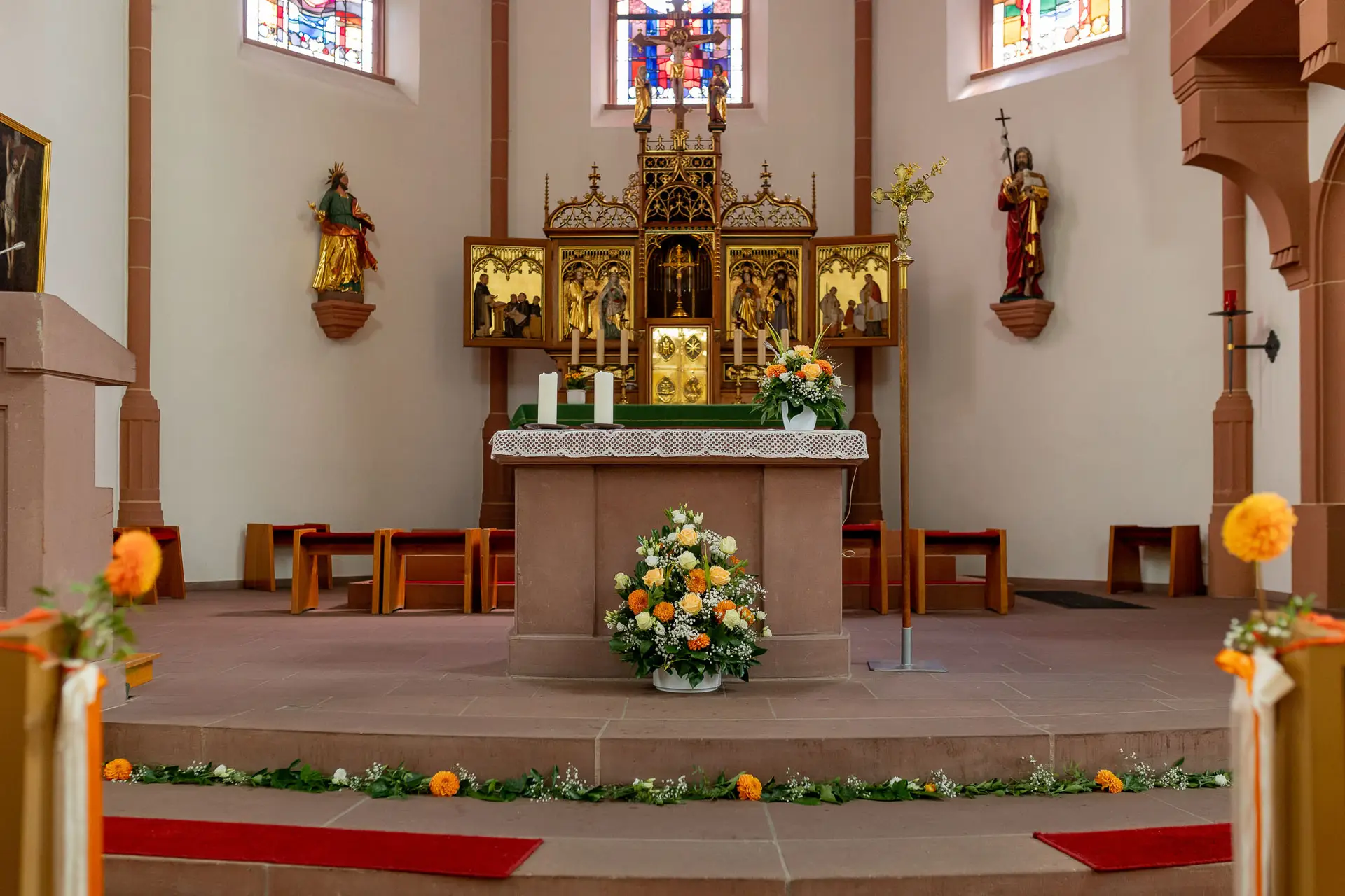 Festlich geschmückter Altar mit Orangeblüten und Kerzen in der Kirche St. Johannes der Täufer