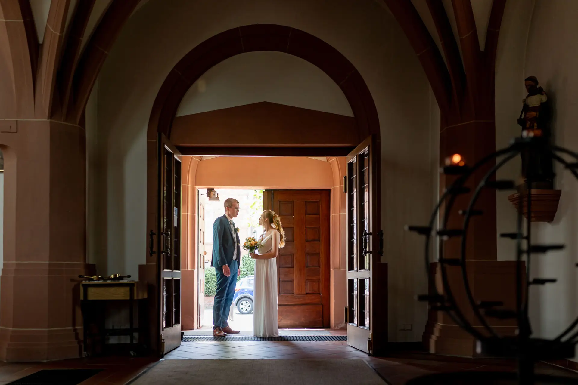 Brautpaar im Eingangsportal der Kirche St. Johannes der Täufer, von innen fotografiert