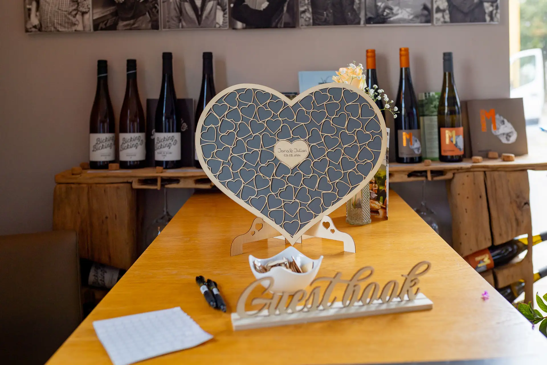 Herzförmiges Holz-Gästebuch mit Guest Book Schriftzug auf Tisch im Wallhäuser Weintreff