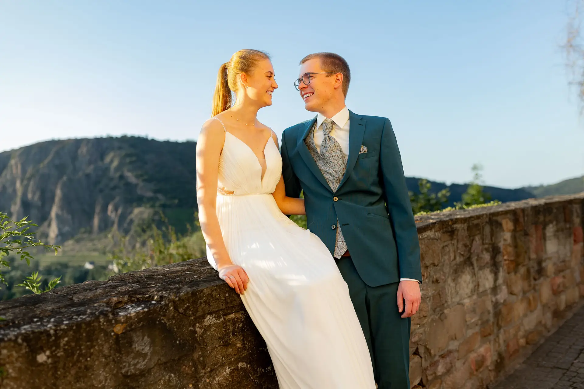Brautpaar lächelt sich an mit Panoramablick über Bad Münster am Stein-Ebernburg im Abendlicht