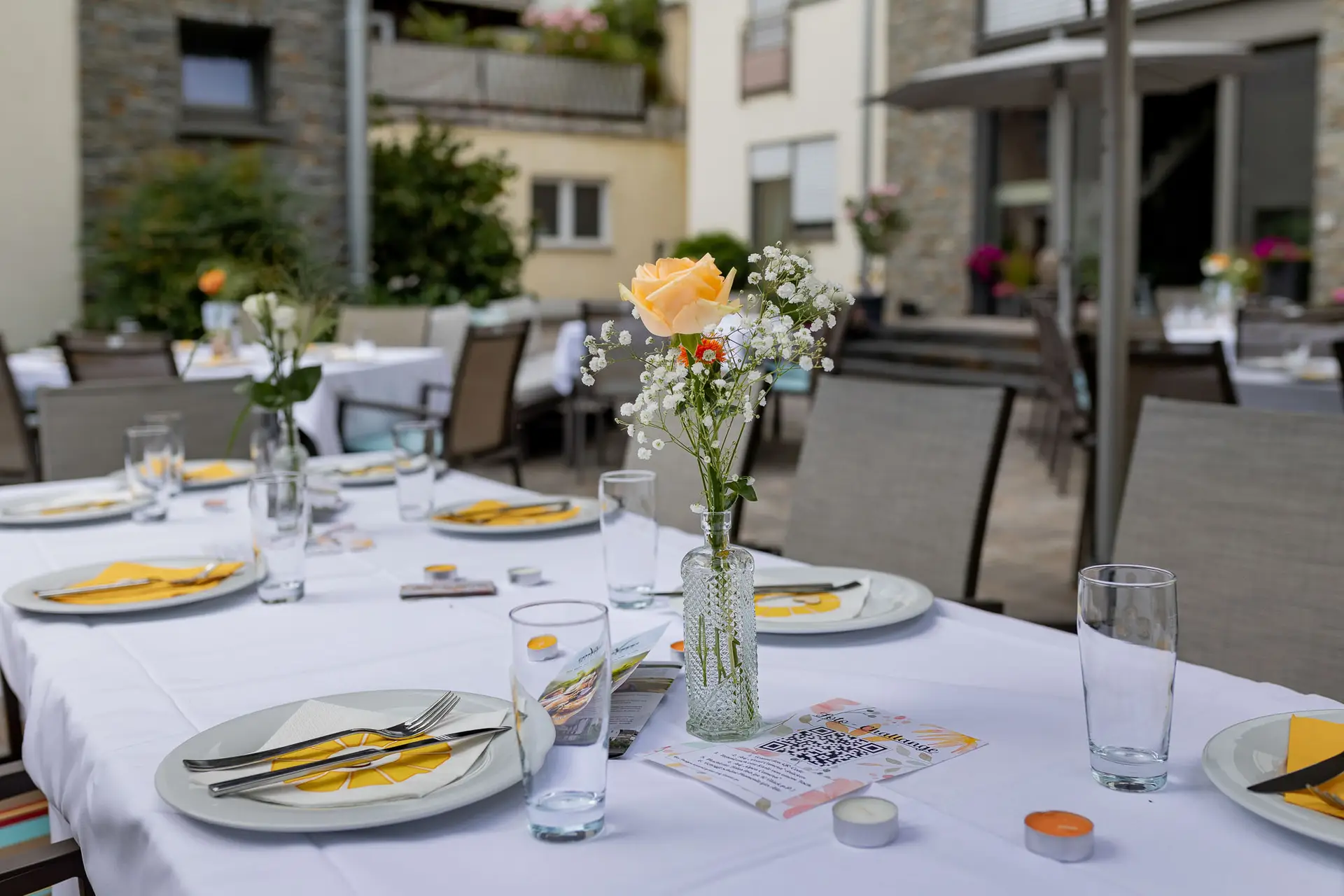 Elegante Tischdekoration mit weißen Blumen und Tischkarte bei der Hochzeitsfeier im Wallhäuser Weintreff