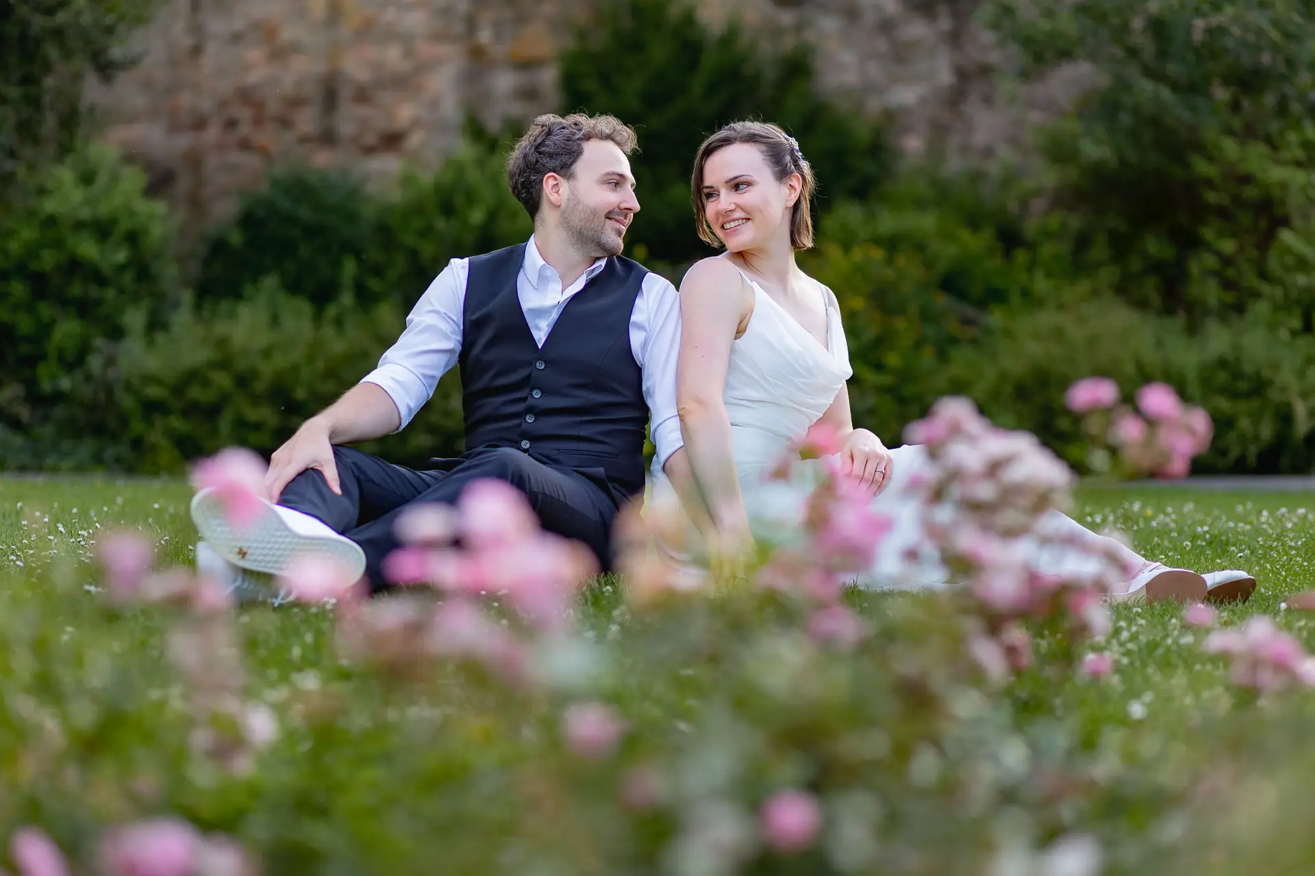 Brautpaar sitzt zusammen umgeben von Blumen im Schlosspark Weinheim