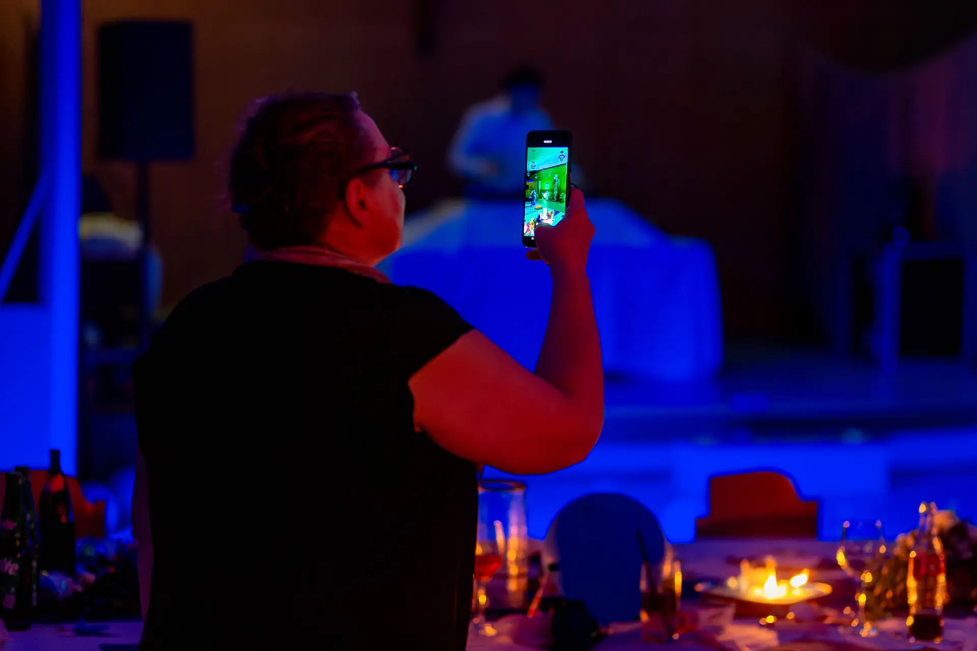 Hochzeitsgast fotografiert den Abend auf dem Smartphone in der Festgaststube