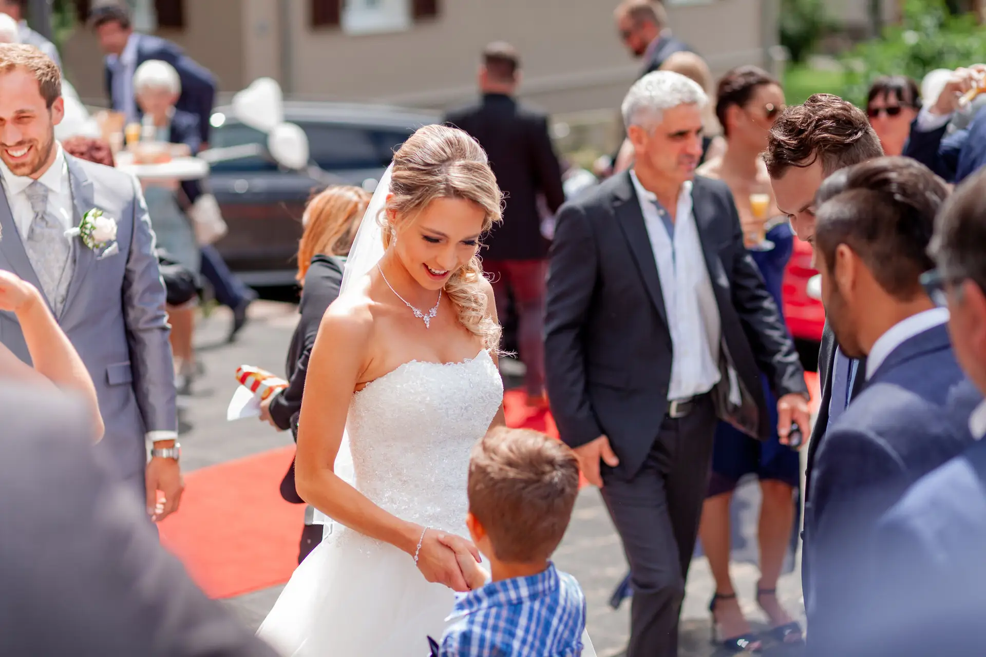 Braut strahlt nach der Trauung unter Gästen vor der Auferstehungskirche