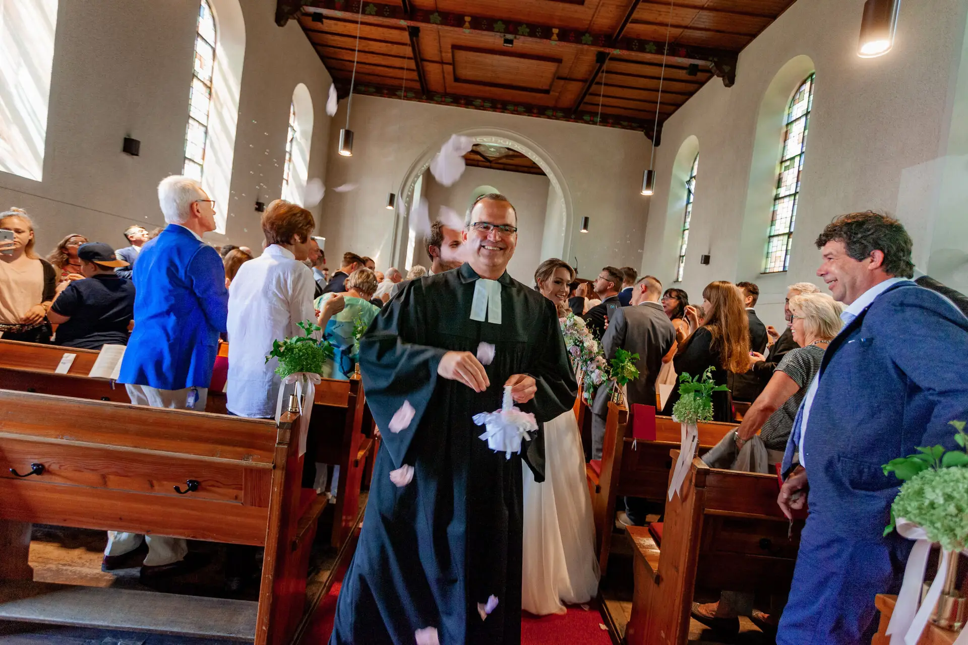 Pfarrer streut begeistert Blütenblätter als Blumenmädchen in der Auferstehungskirche