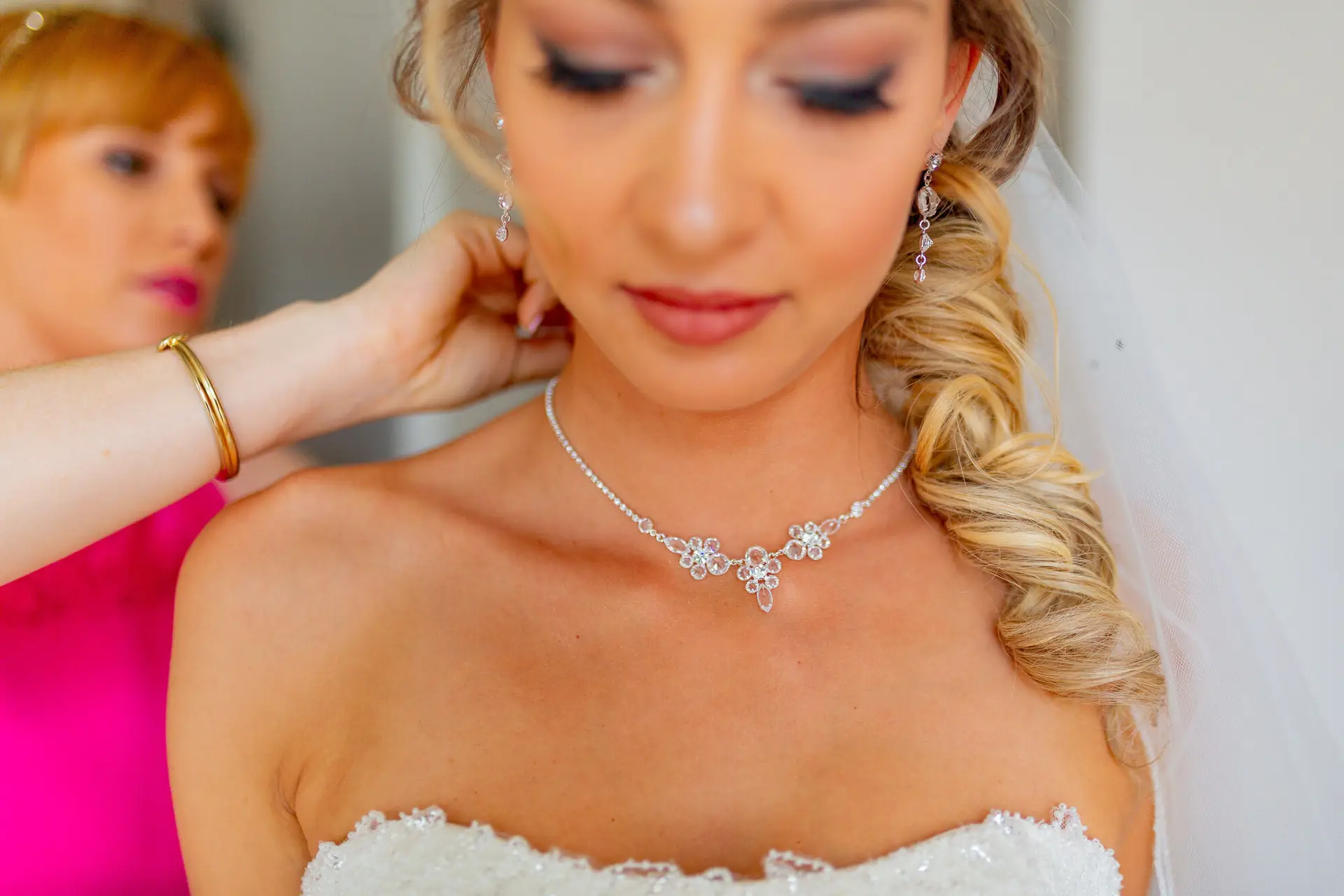 Braut legt blaues Strumpfband an vor der Hochzeit