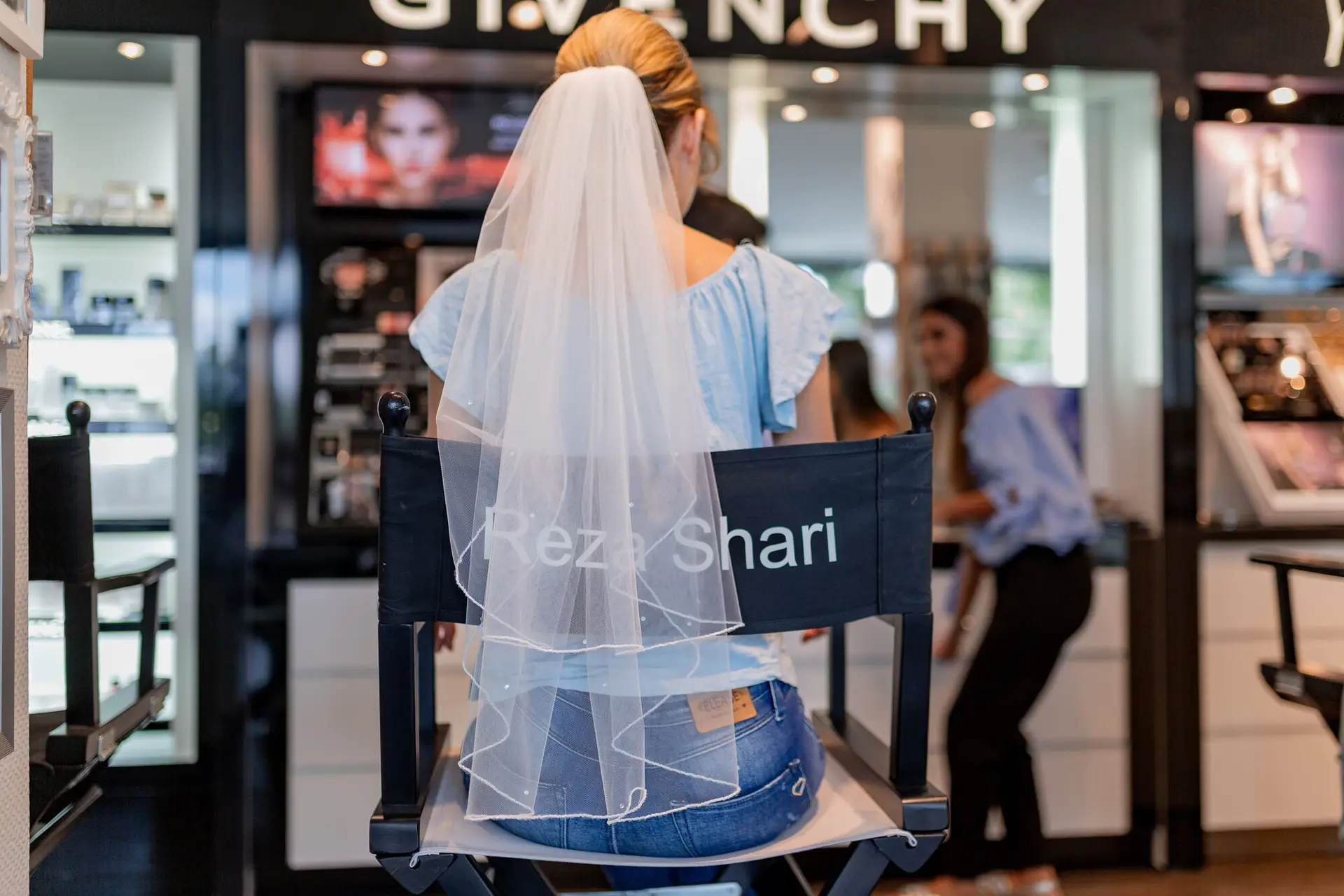 Braut mit Schleier sitzt beim Friseur Reza Shari während Getting Ready