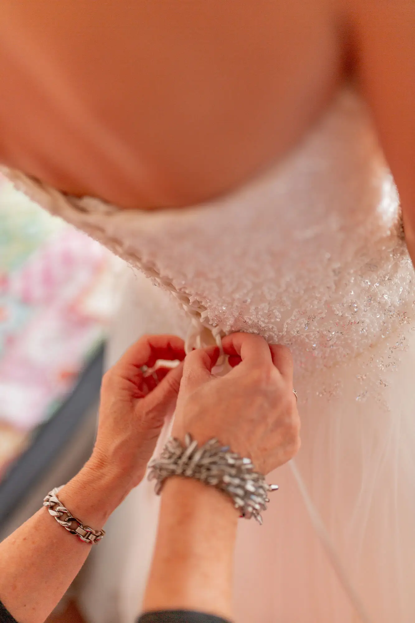 Nahaufnahme Brautschmuck: Halskette und Ohrringe werden angelegt