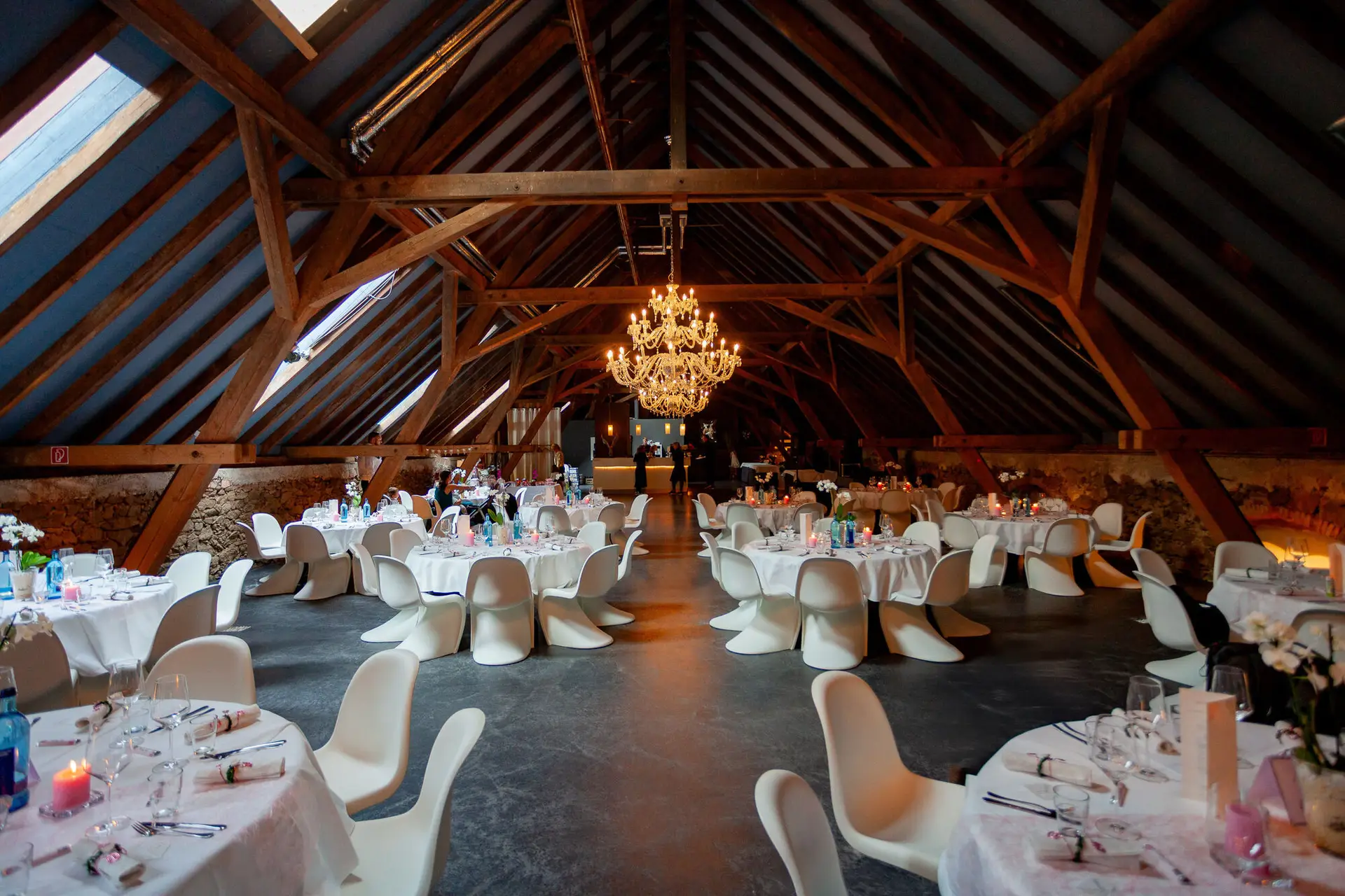 Festsaal in der Scheune des Hofgut Hohenstein mit gedeckten Tischen und Kristallleuchter