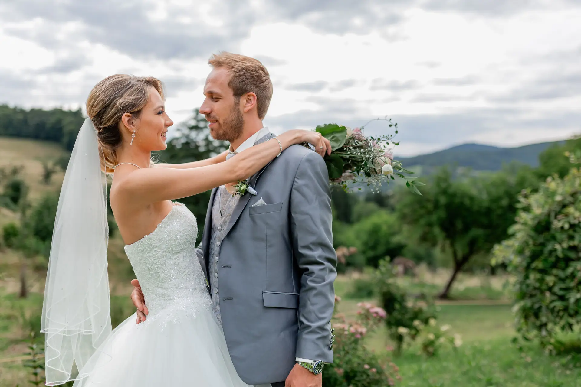 Brautpaar lächelt sich verliebt an im Garten des Hofgut Hohenstein