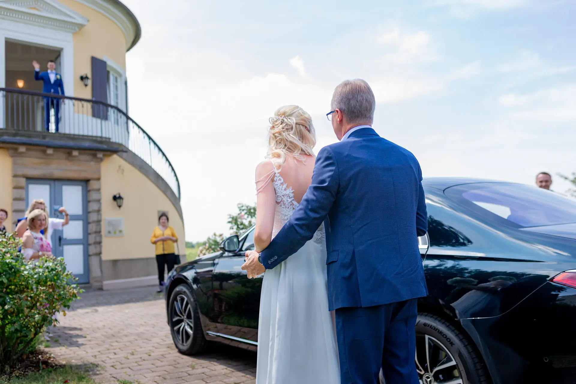 Braut Liane wird zum Schlosspavillon geführt, Bräutigam Kevin wartet oben auf dem Balkon