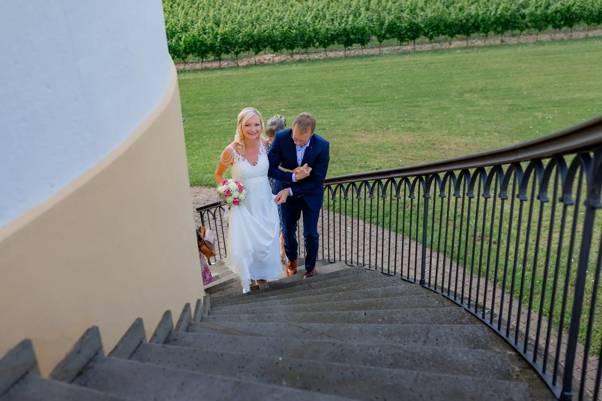 Brautpaar Liane und Kevin steigt die Treppe des Schlosspavillon Kleinniedesheim hinunter