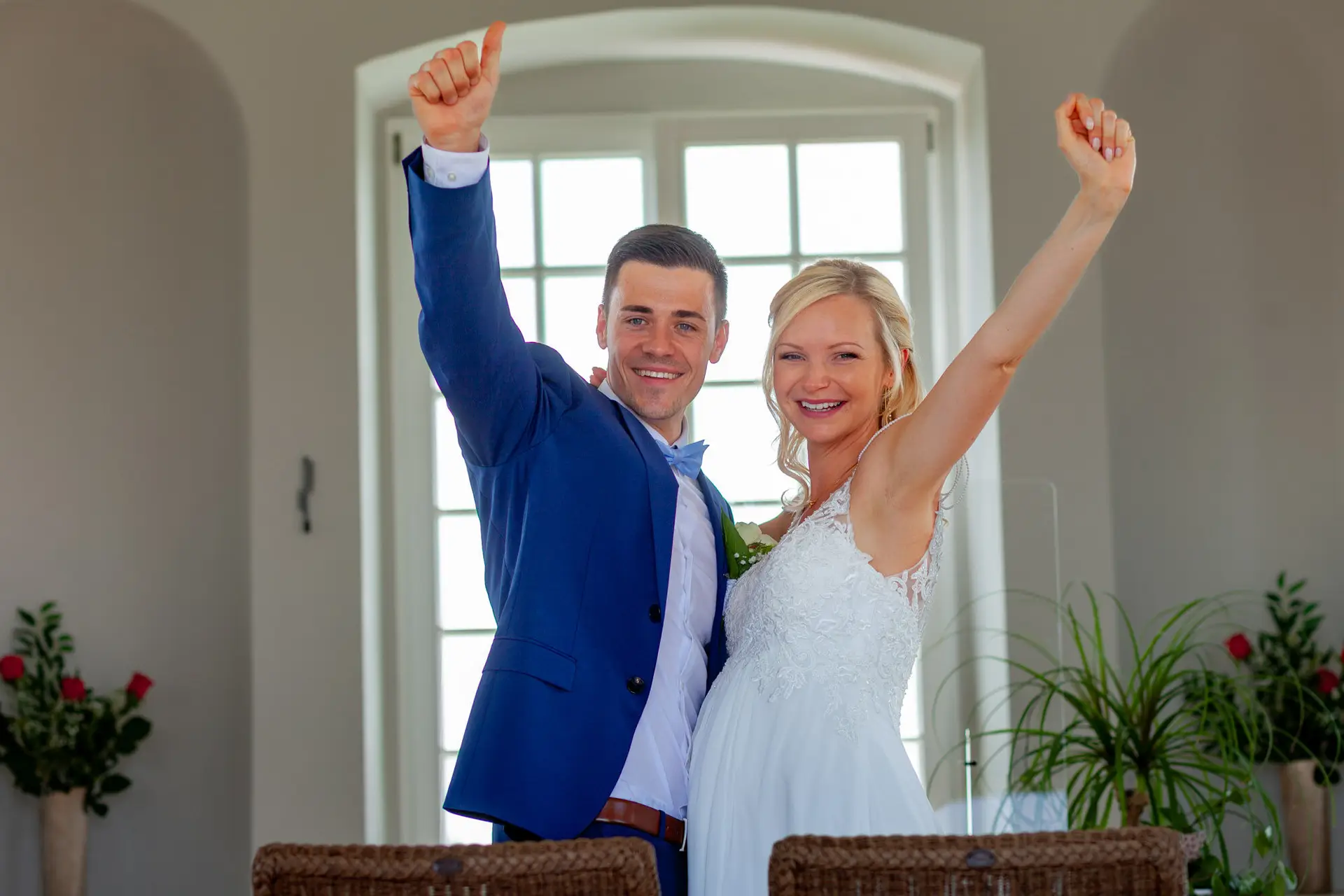 Liane und Kevin jubeln mit erhobenen Armen nach dem Ja-Wort im Schlosspavillon