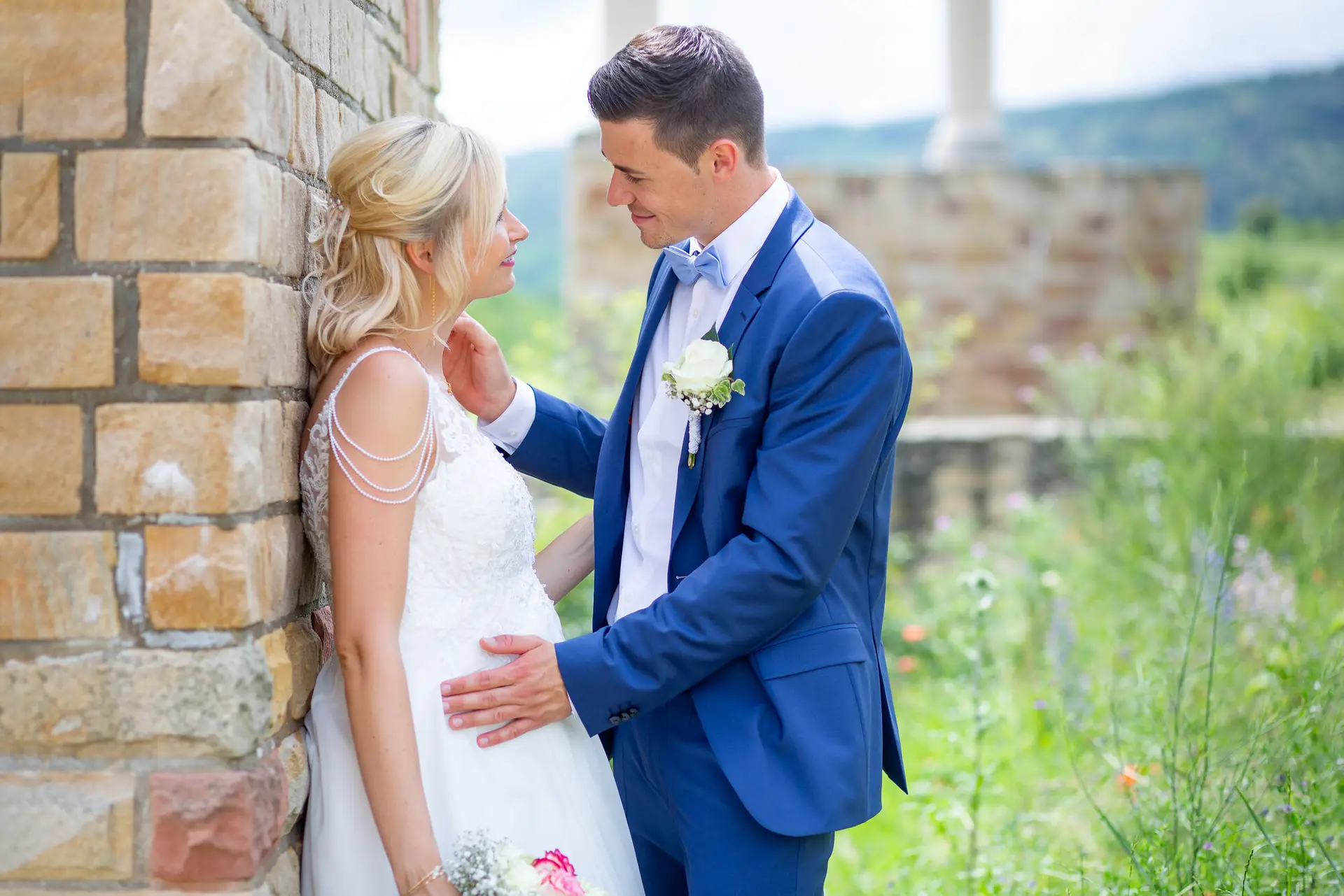 Liane und Kevin lachen vor einer historischen Steinmauer – Brautpaarshooting Pfalz