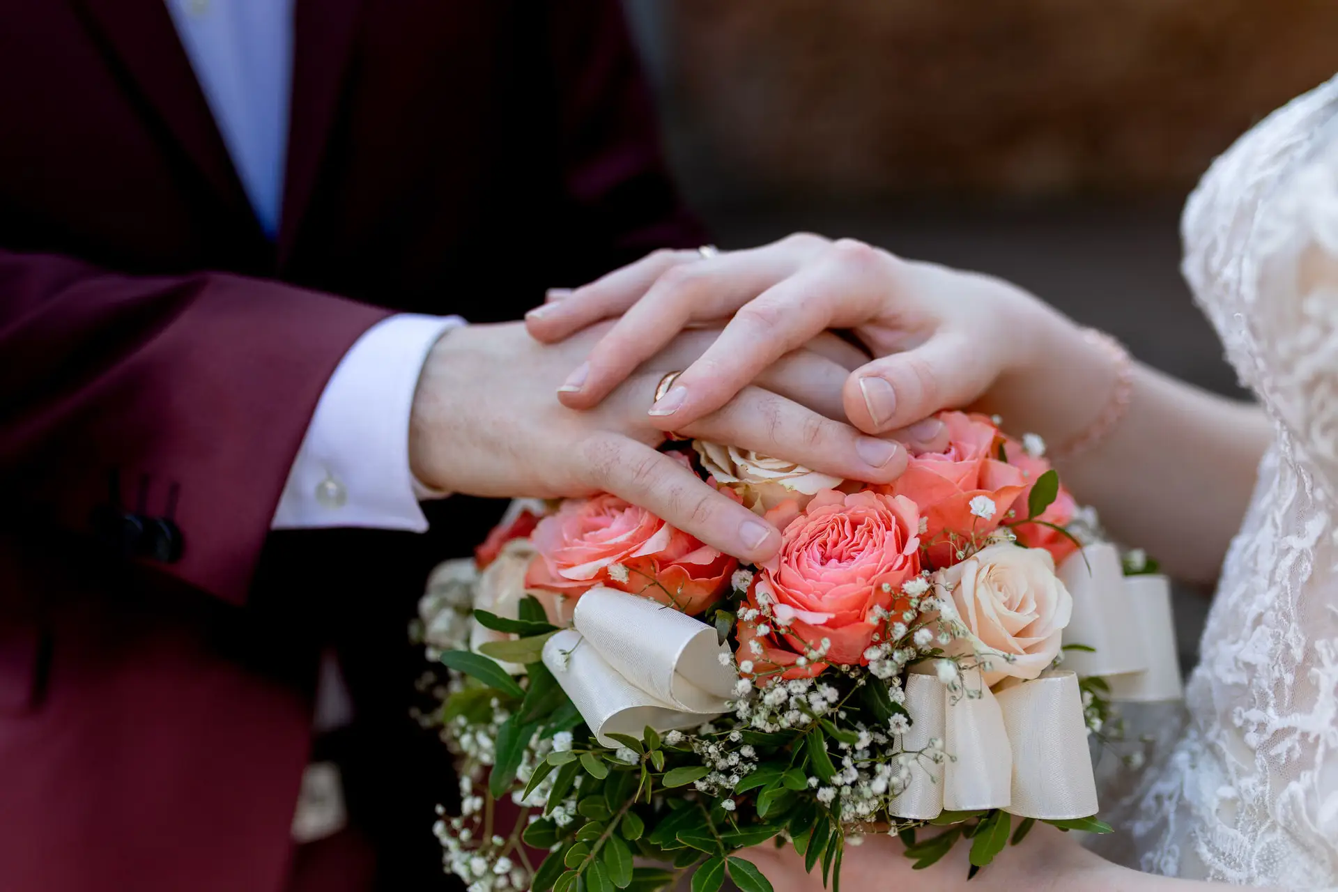 Brautpaar hält sich zärtlich an den Händen mit dem Brautstrauß, verträumter Blick in die Abendsonne