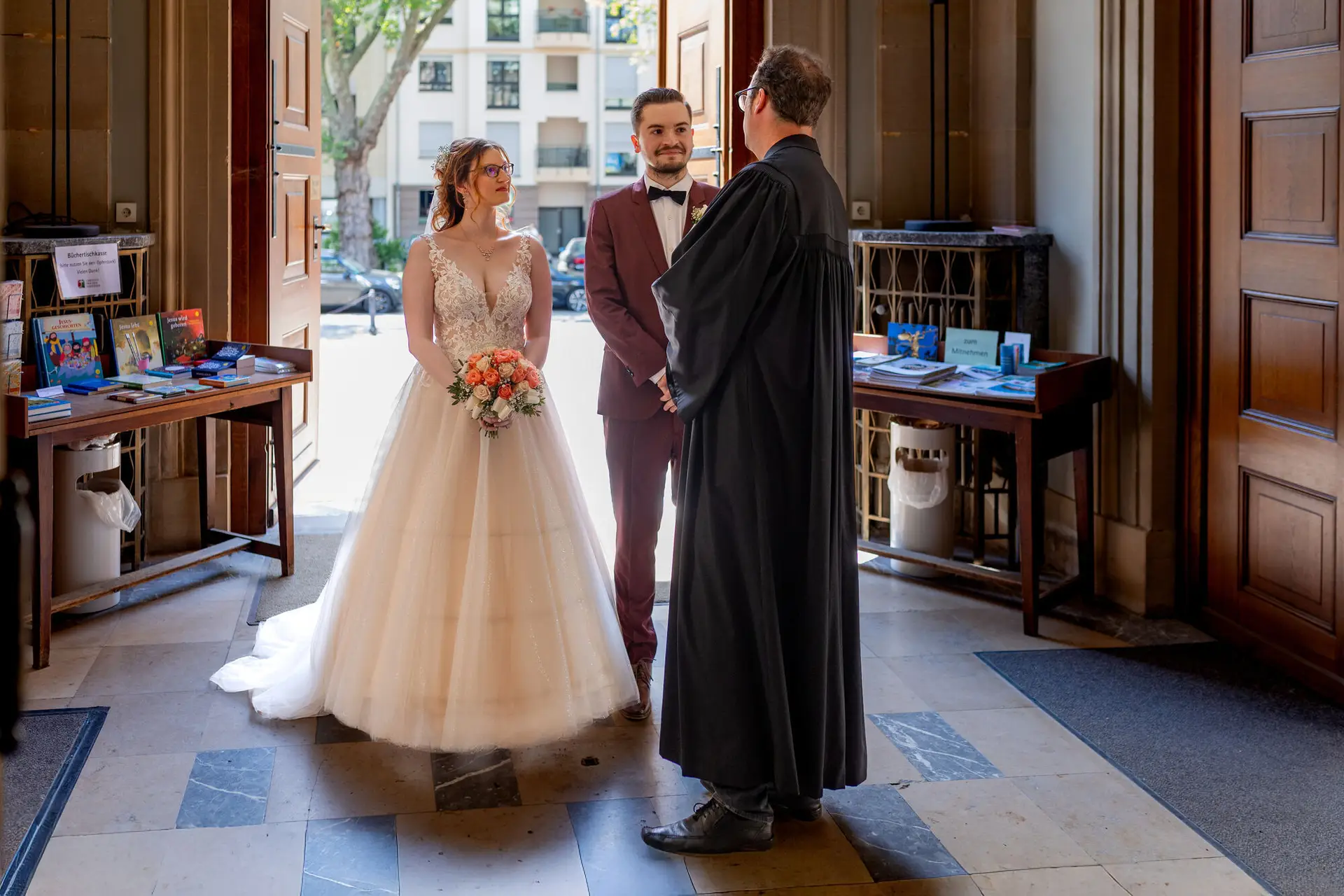 Brautpaar begrüßt den Pfarrer im Eingang der Christuskirche Mannheim vor der Trauung