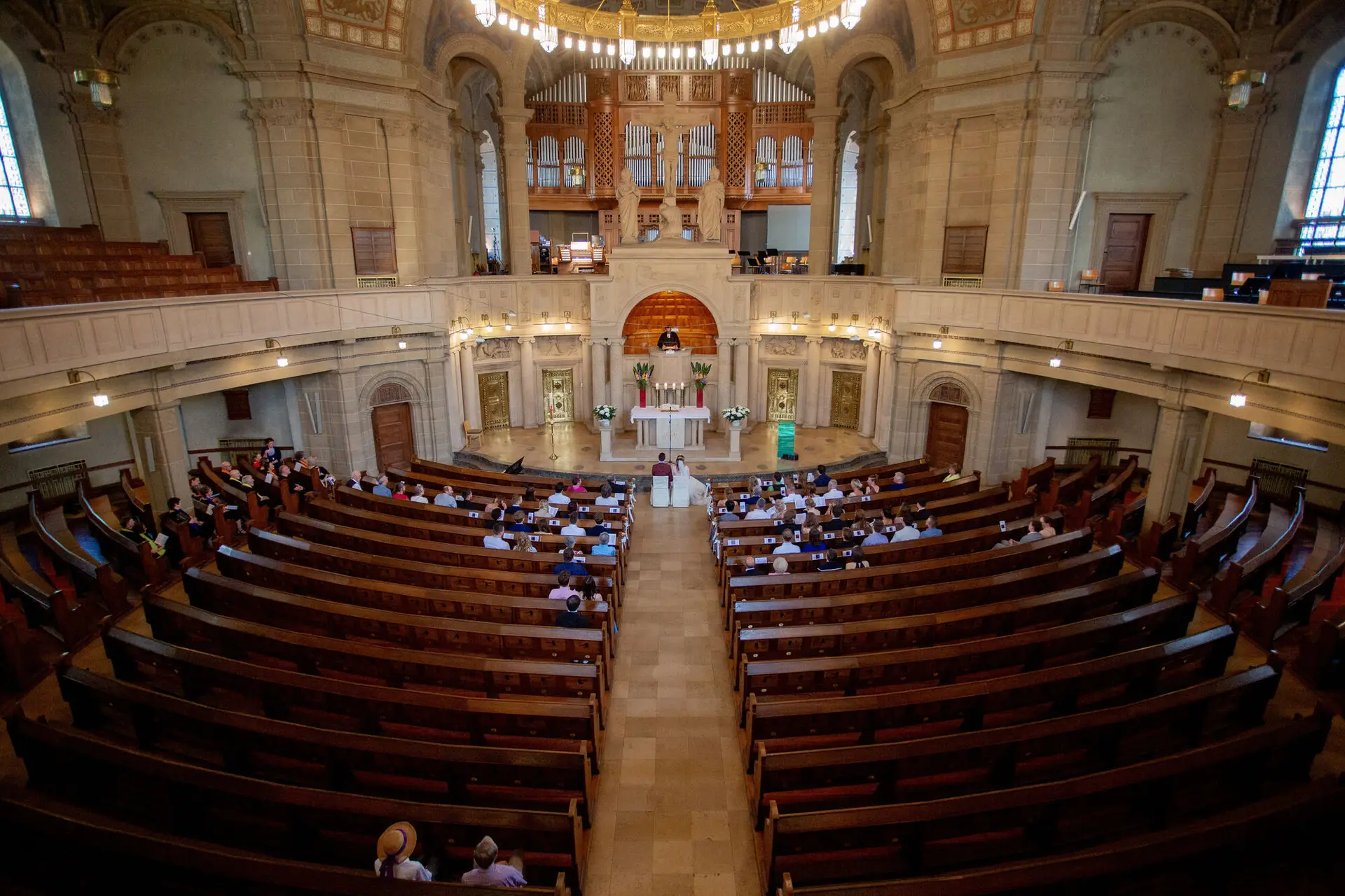 Hochzeitszeremonie im weitläufigen Kirchenschiff der Christuskirche, Gäste in den Bänken vor dem Altar