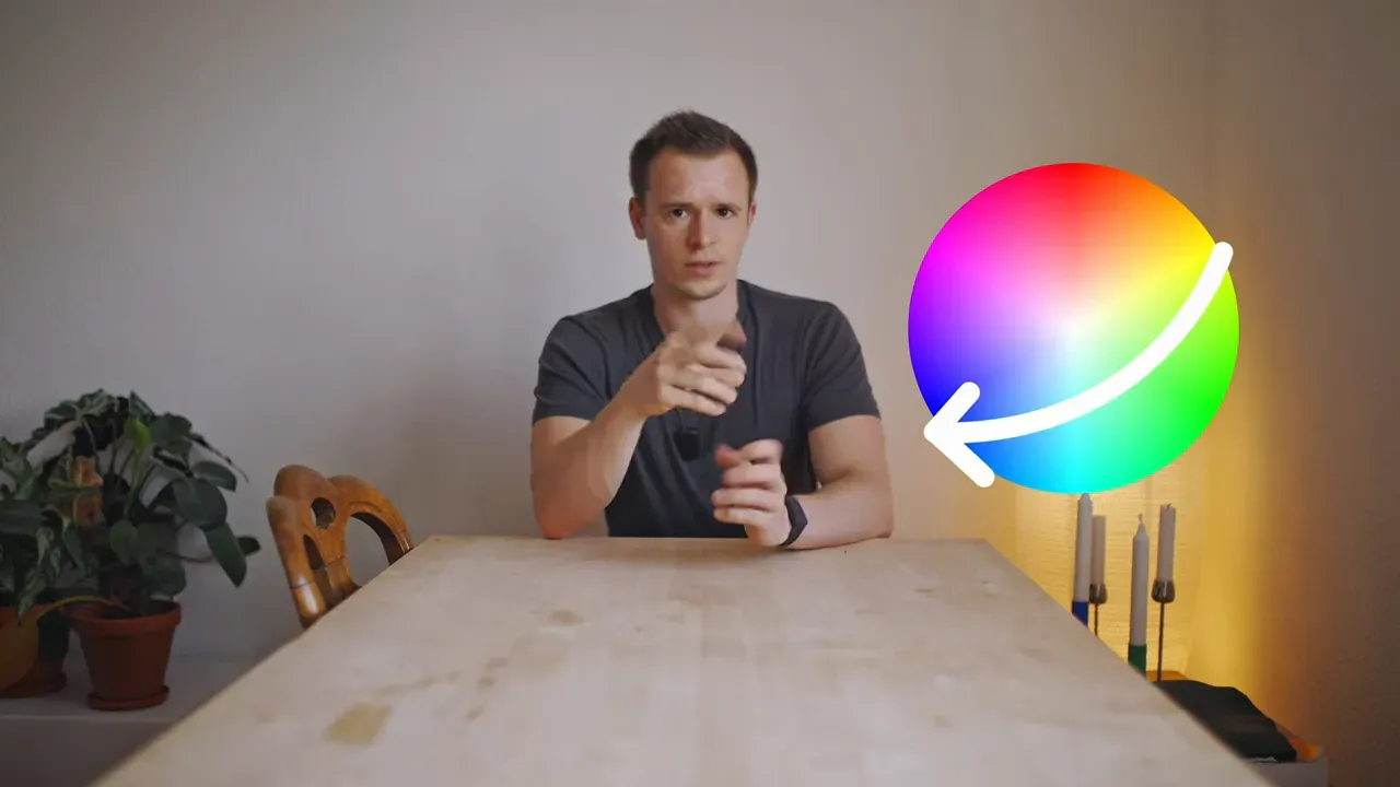 Moderator zeigt auf einen großen Farbkreis mit weißem Pfeil, der die Komplementärrichtung markiert