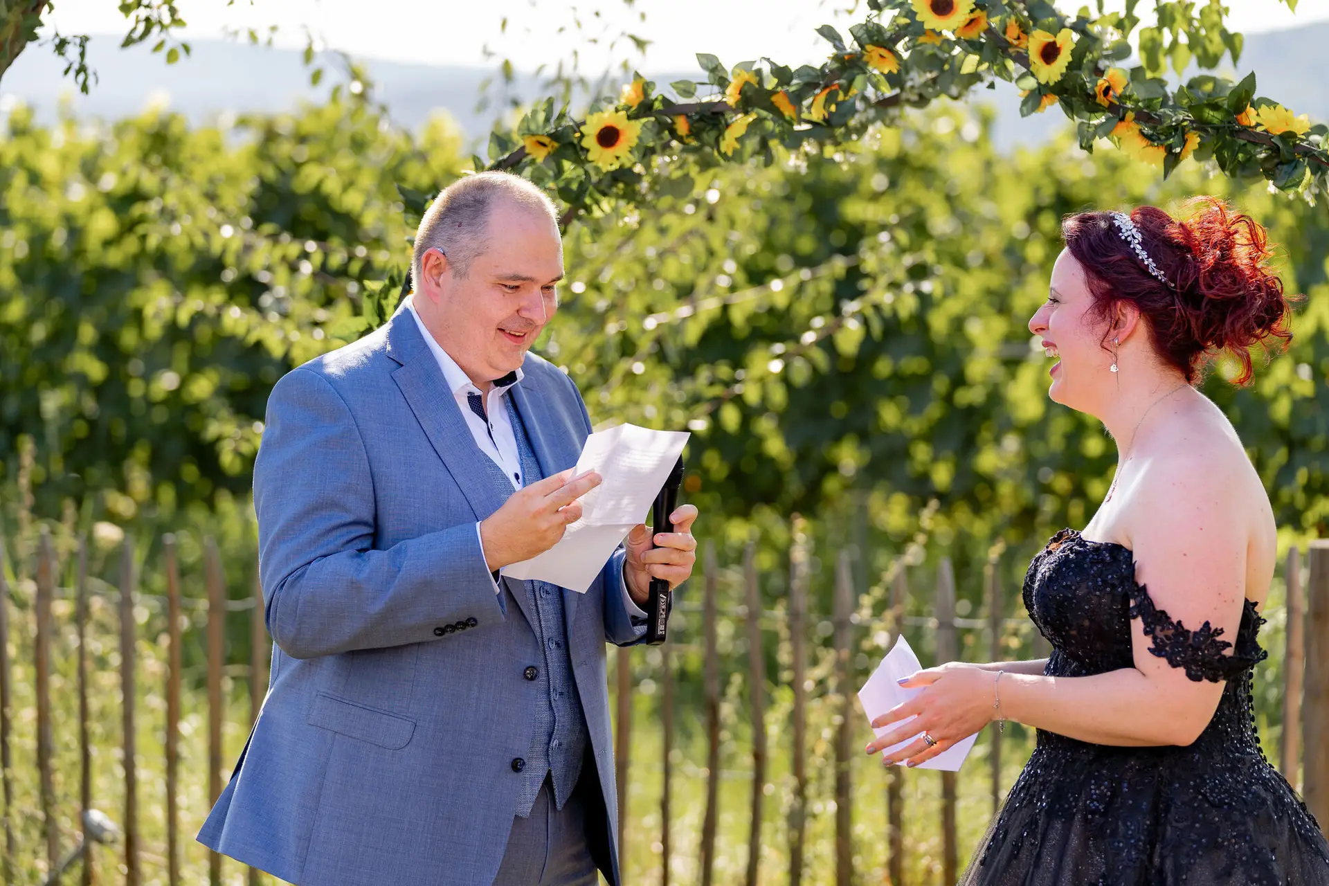Bräutigam liest sein Eheversprechen vor während Braut herzlich lacht