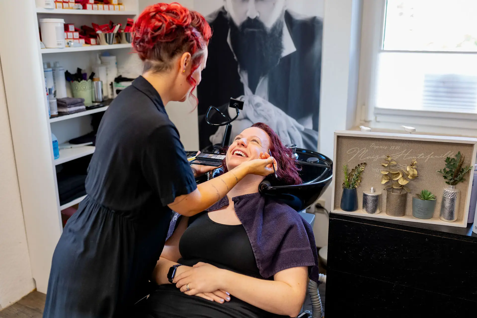 Braut lacht glücklich während des Haarewaschens im Friseursalon in Neustadt
