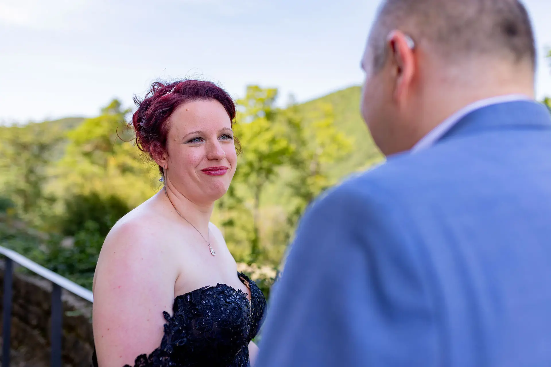 Nahaufnahme Braut mit rotem Haarkranz blickt Bräutigam verliebt an vor Hambacher Schloss