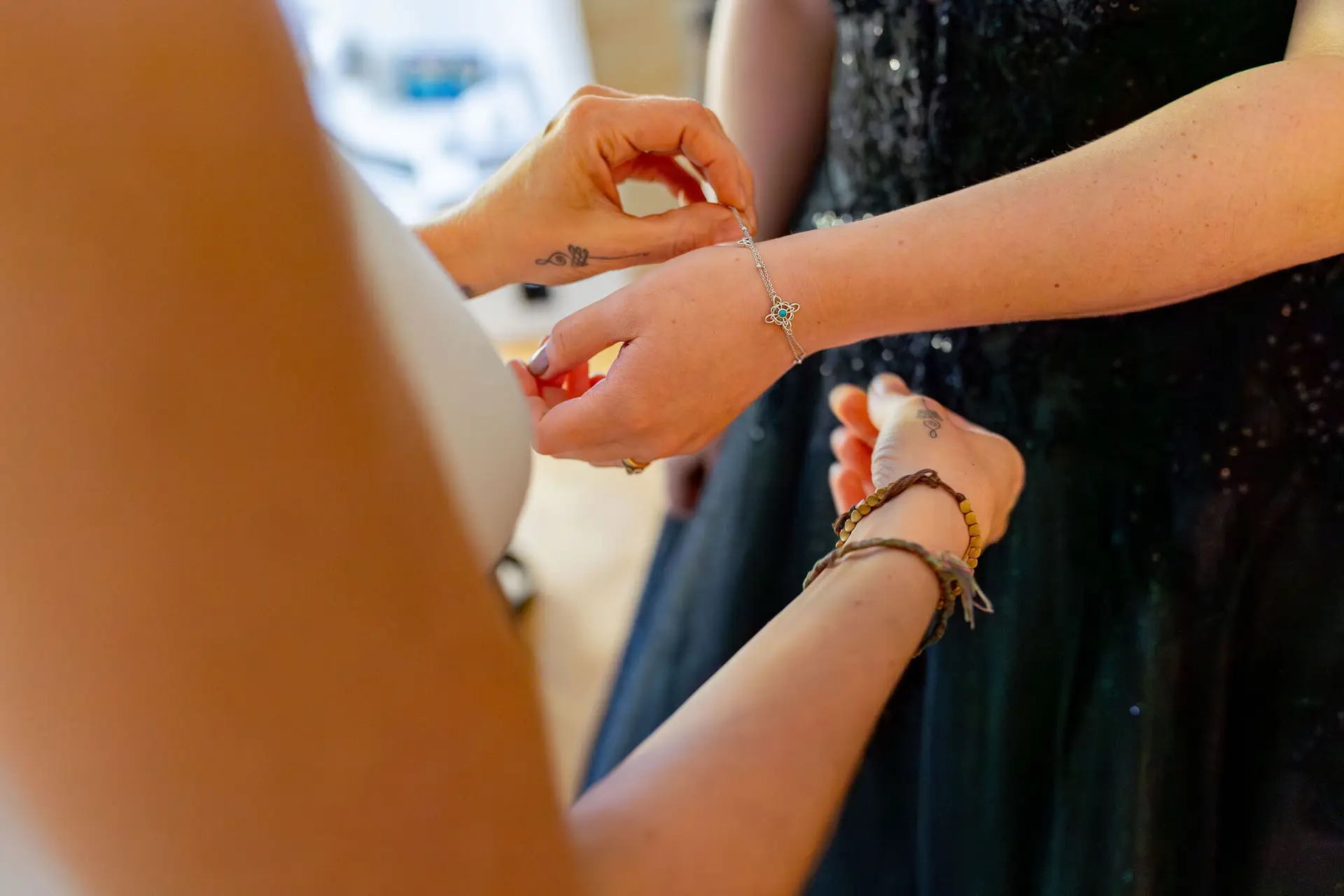 Detailaufnahme vom Anlegen des Brautarmbands mit filigranem Schmuck